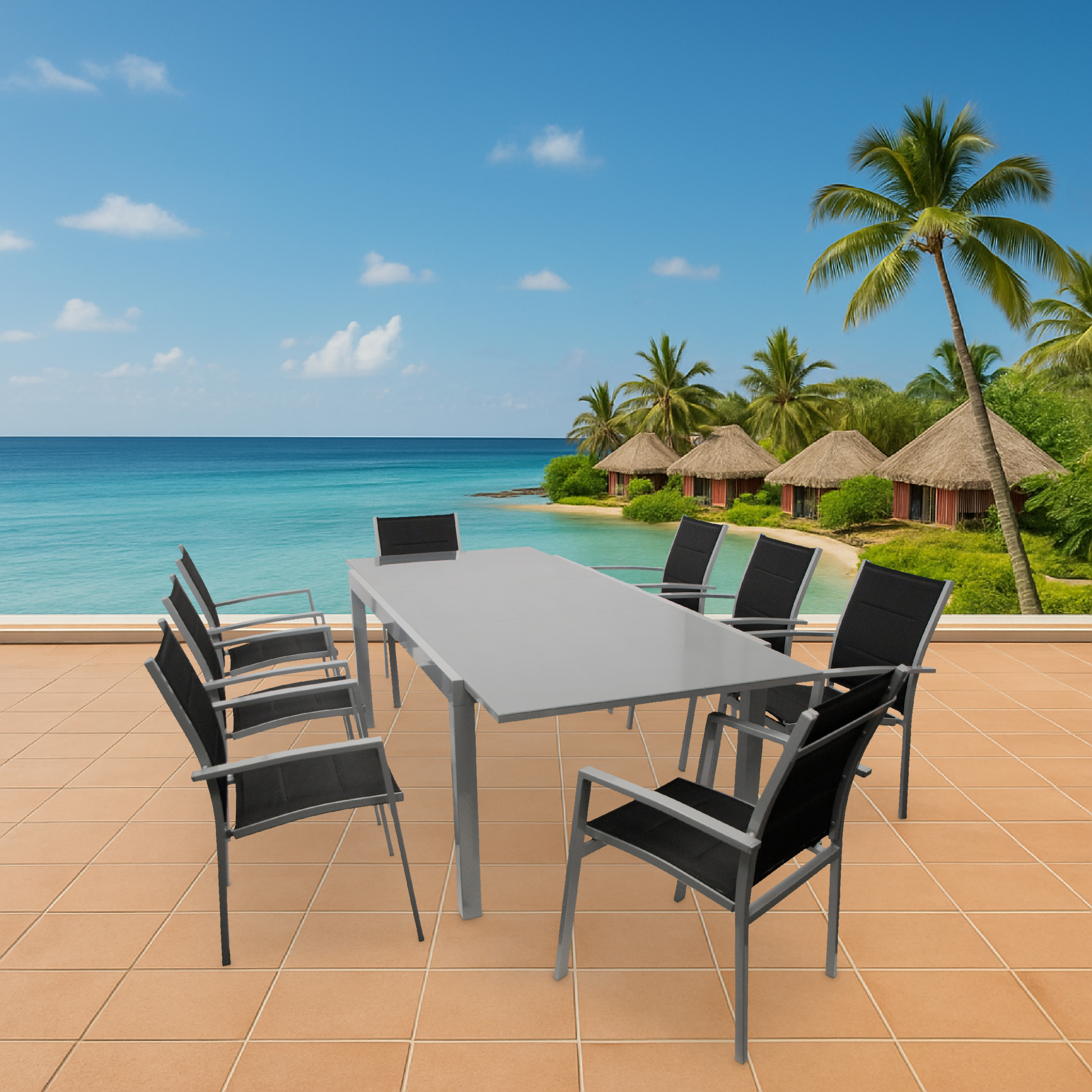 Ein Tisch und Stühle auf einer Terrasse mit Blick auf das Meer und Hütten.