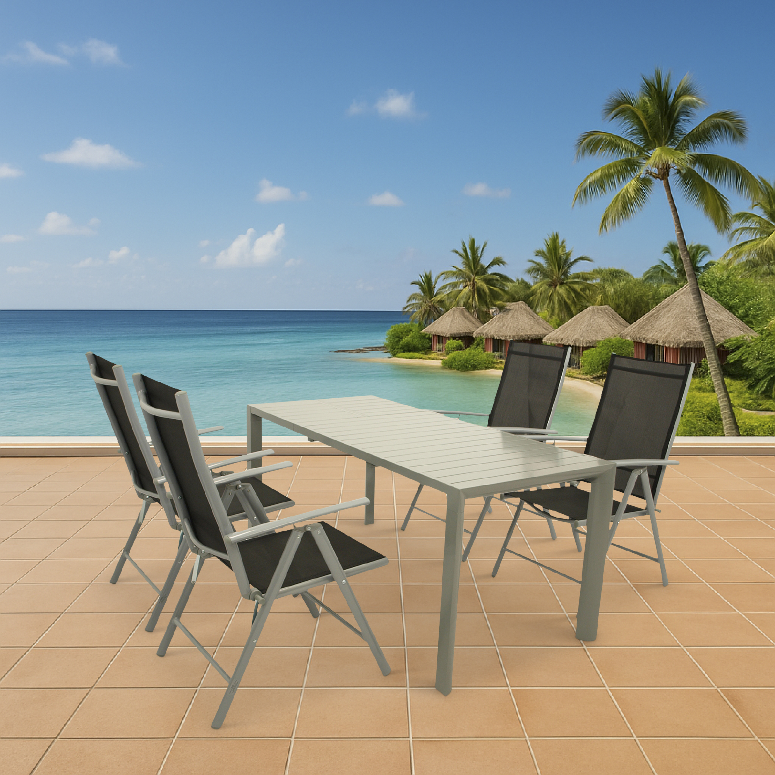 Ein Tisch und vier Stühle stehen auf einer Terrasse mit Blick auf das Meer und tropische Hütten.