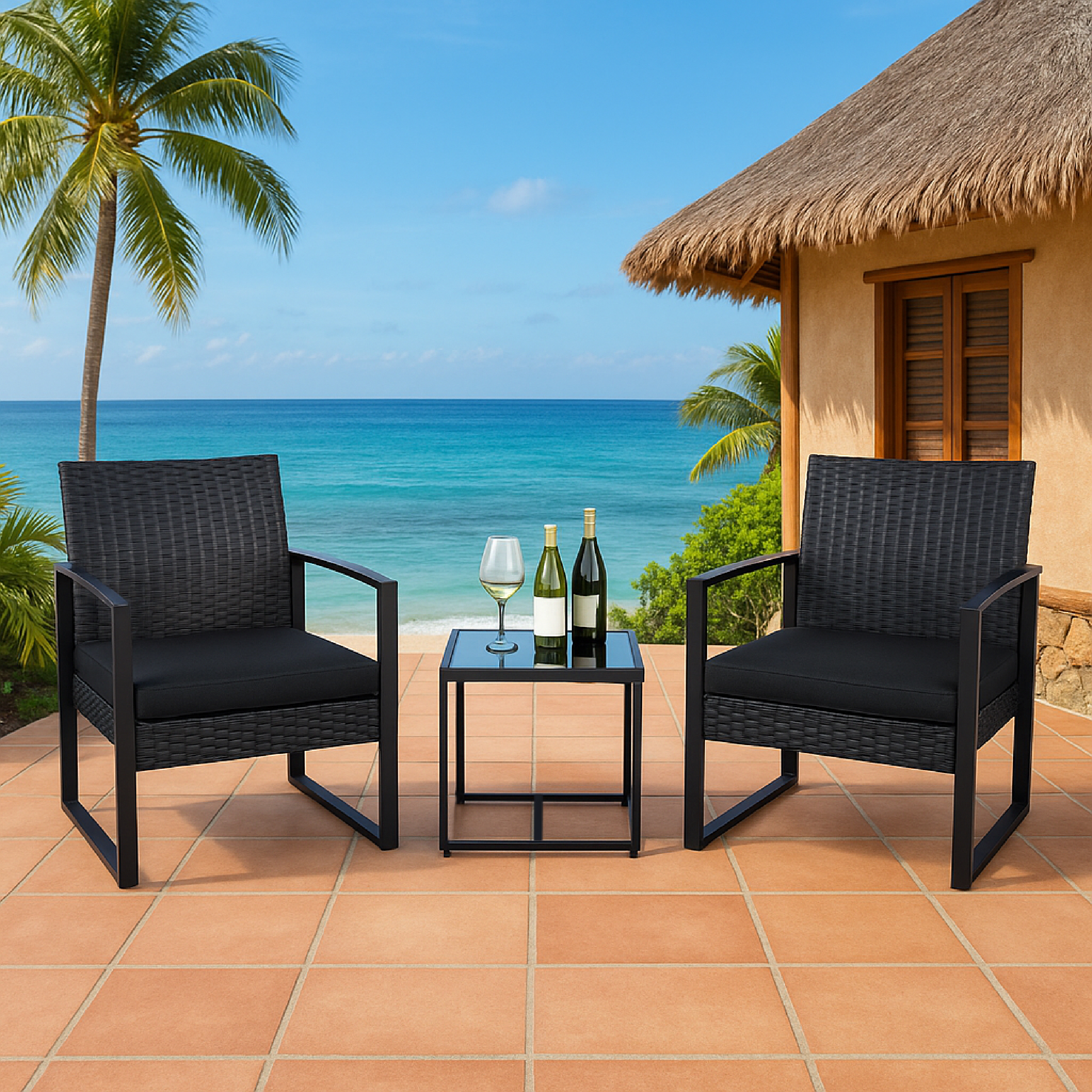 Zwei schwarze Rattansessel mit Kissen, ein Glastisch mit Wein und Glas am Meer.