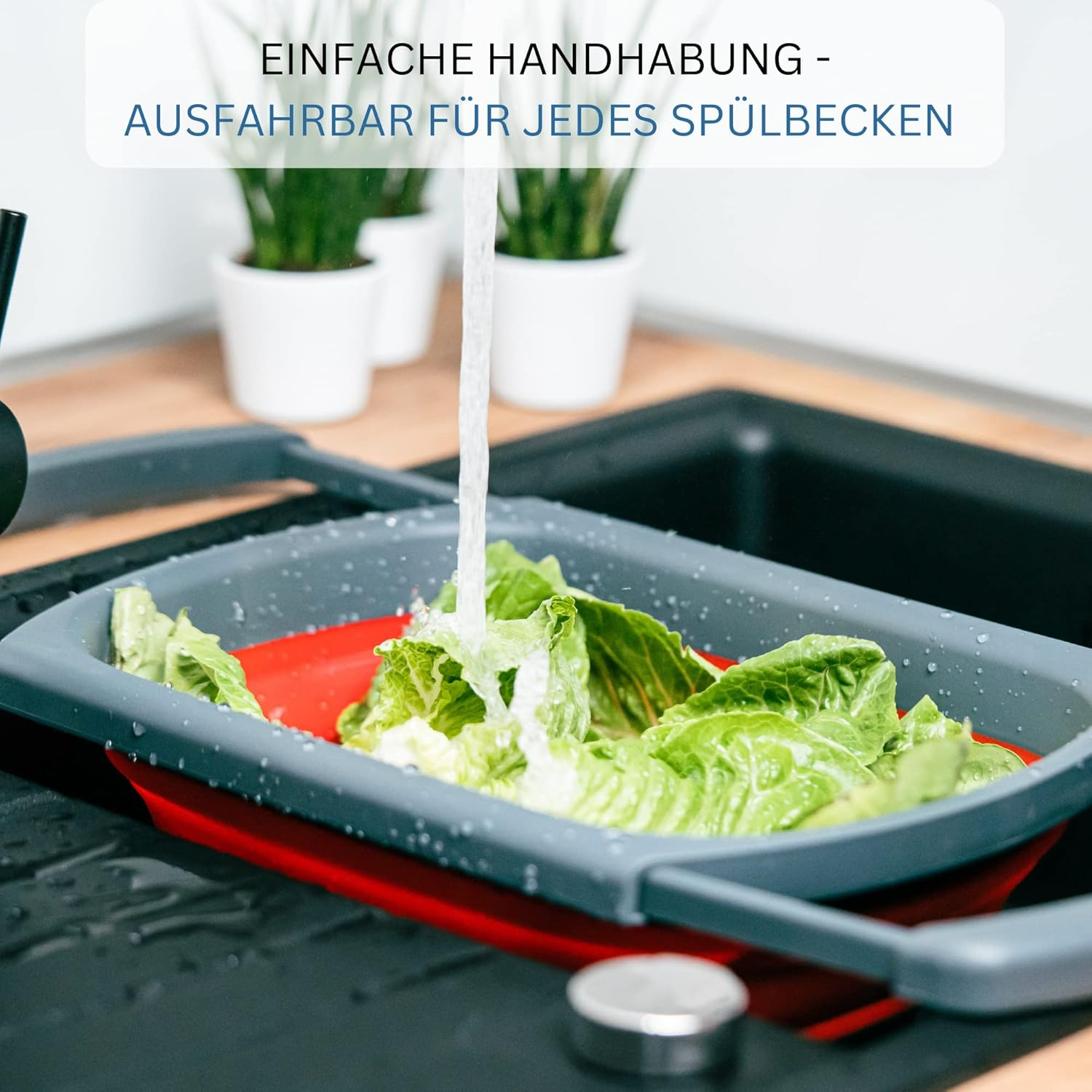 Grüner Salat wird in einem grauen Sieb unter fließendem Wasser gewaschen.