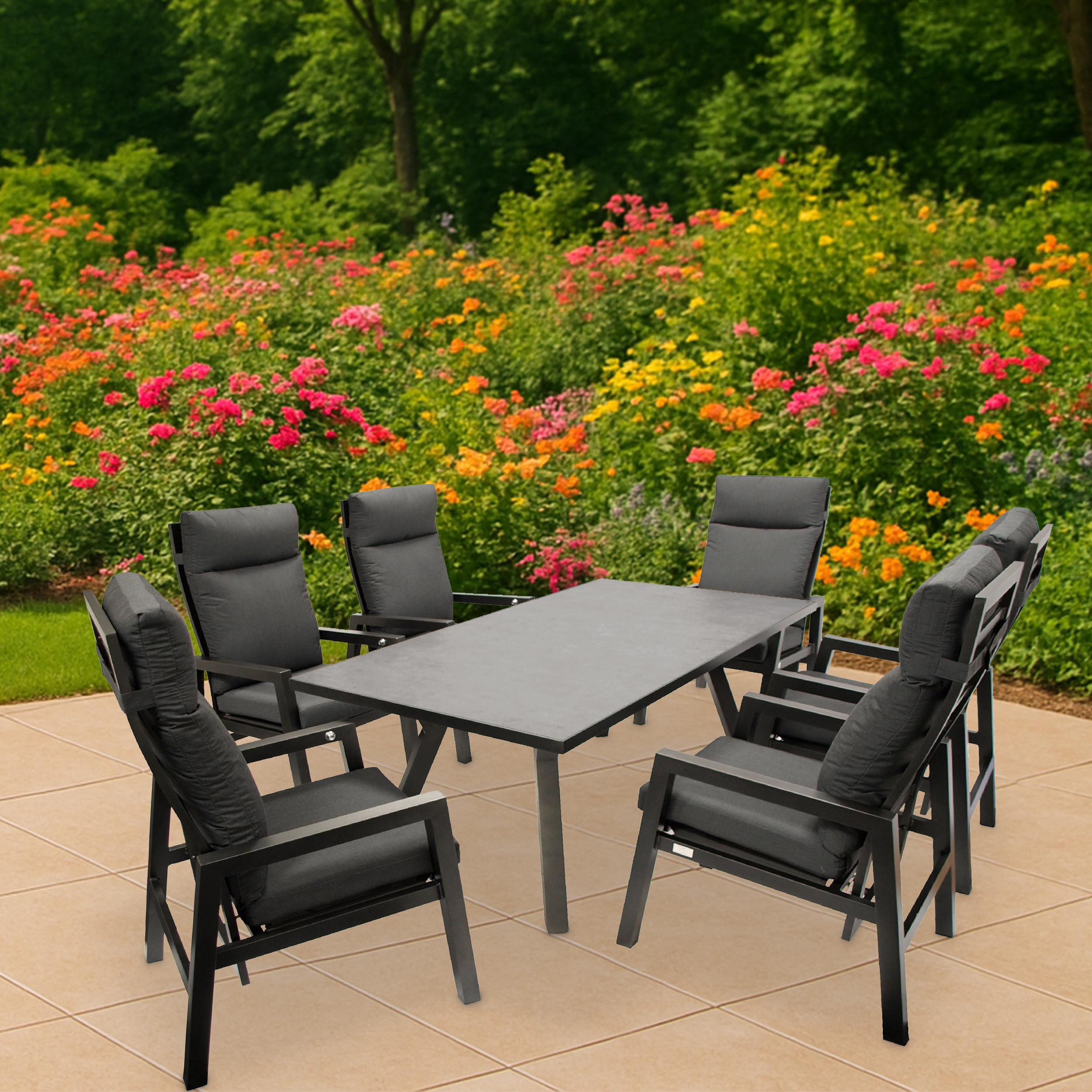 Ein schwarzer Gartentisch mit sechs Stühlen steht auf einer Terrasse vor einem blühenden Blumenbeet.