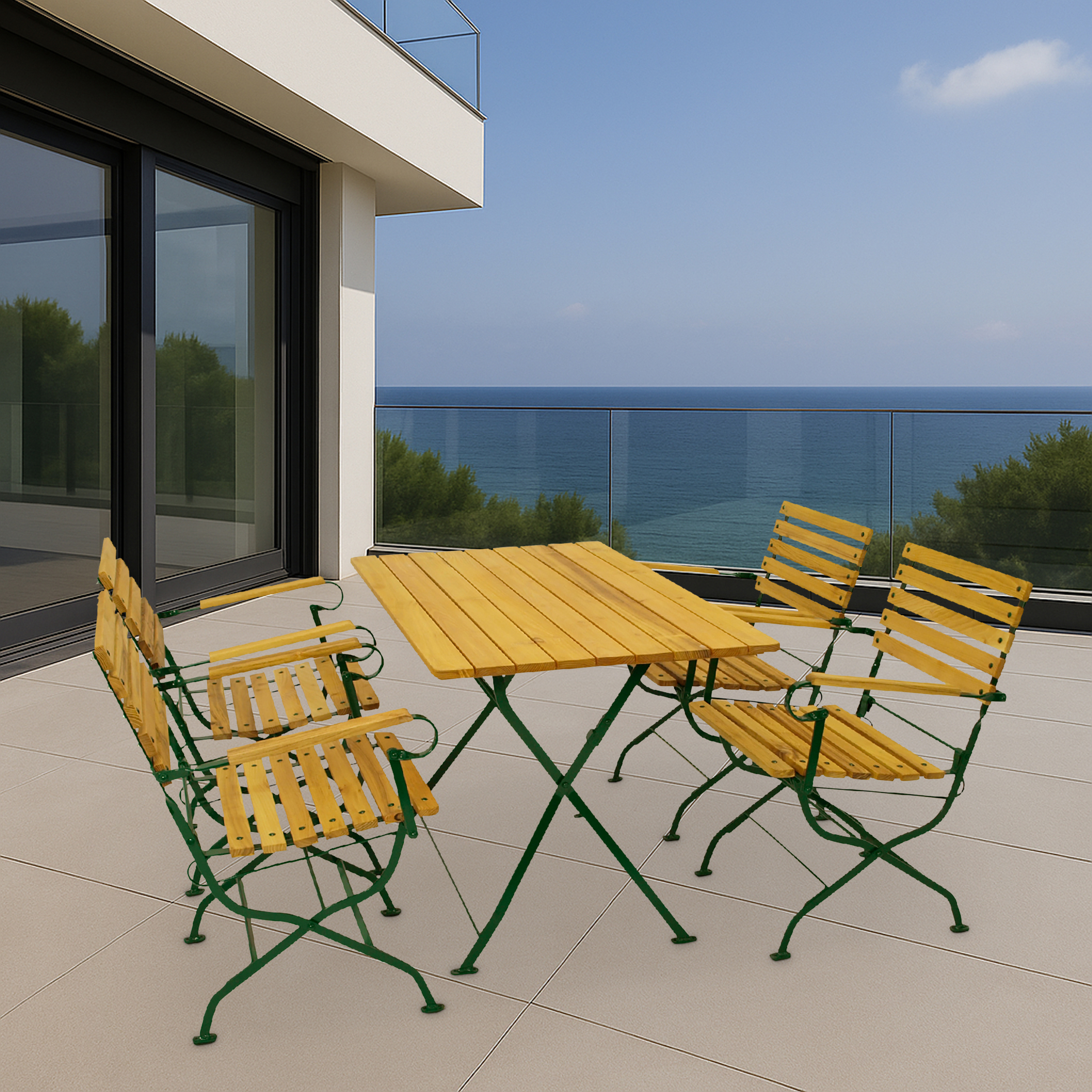 Holztisch und vier Stühle mit grünen Metallgestellen auf einer Terrasse am Meer.