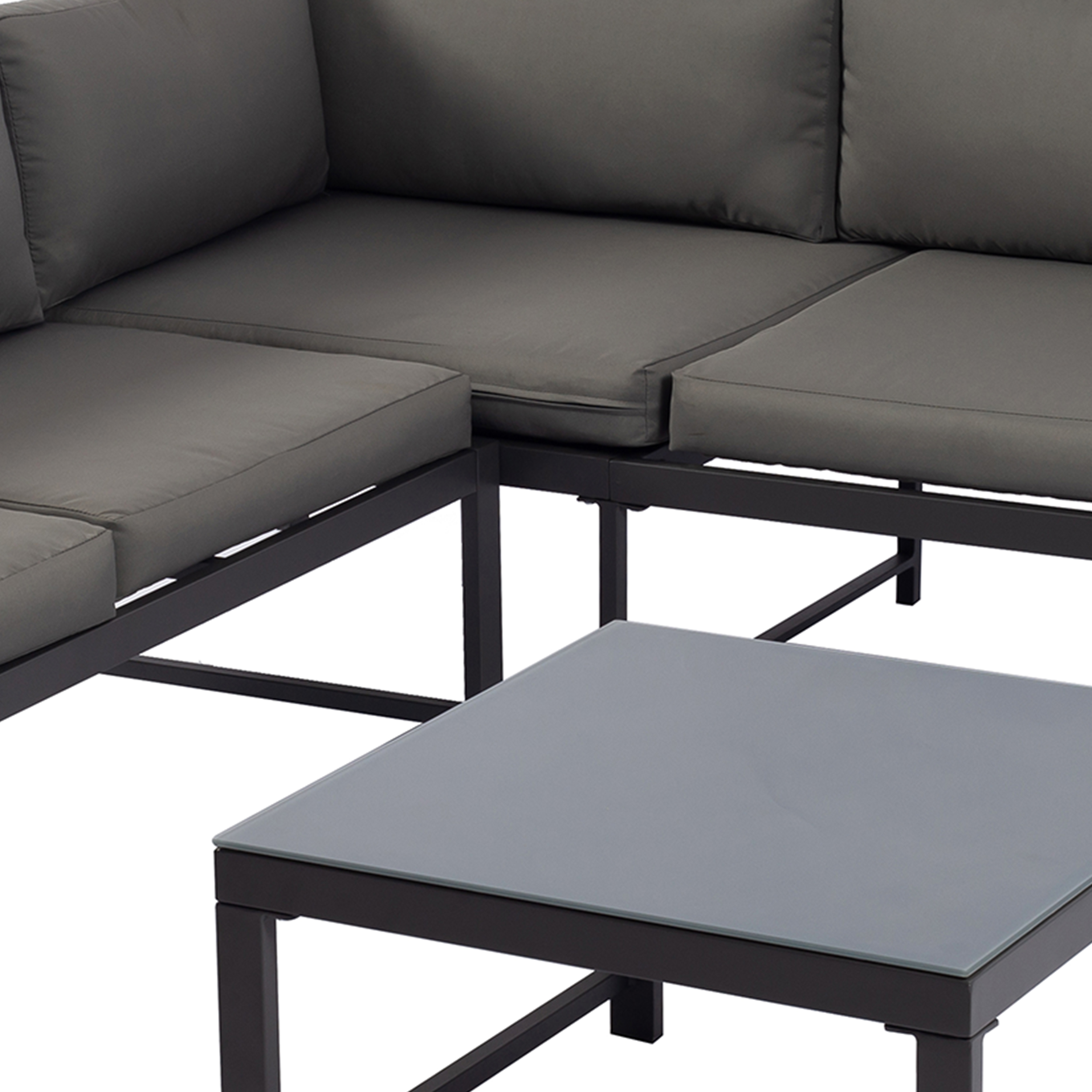Ein graues Ecksofa mit einem Glastisch davor.