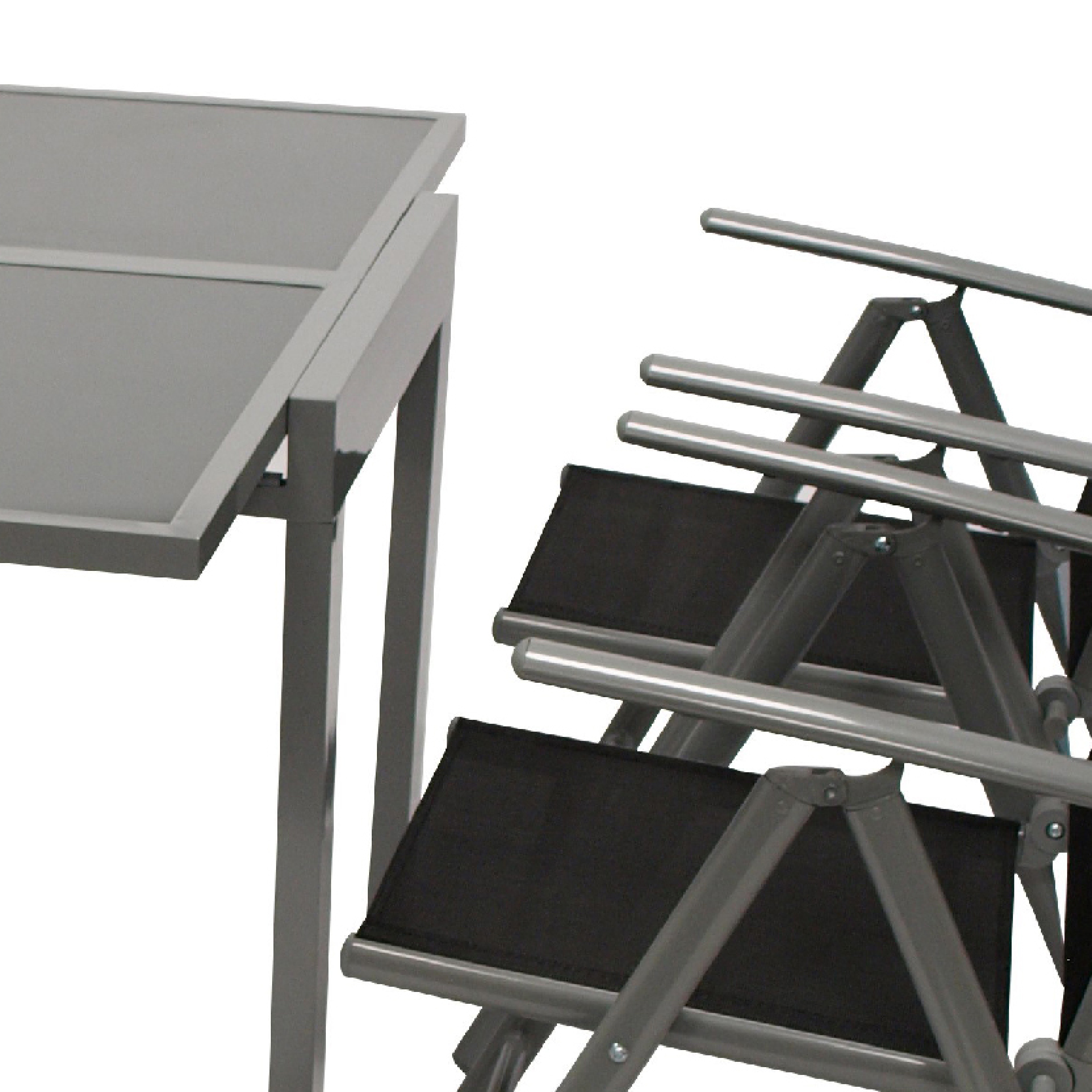 Grauer Tisch und zusammengeklappte Stühle mit schwarzem Stoff.