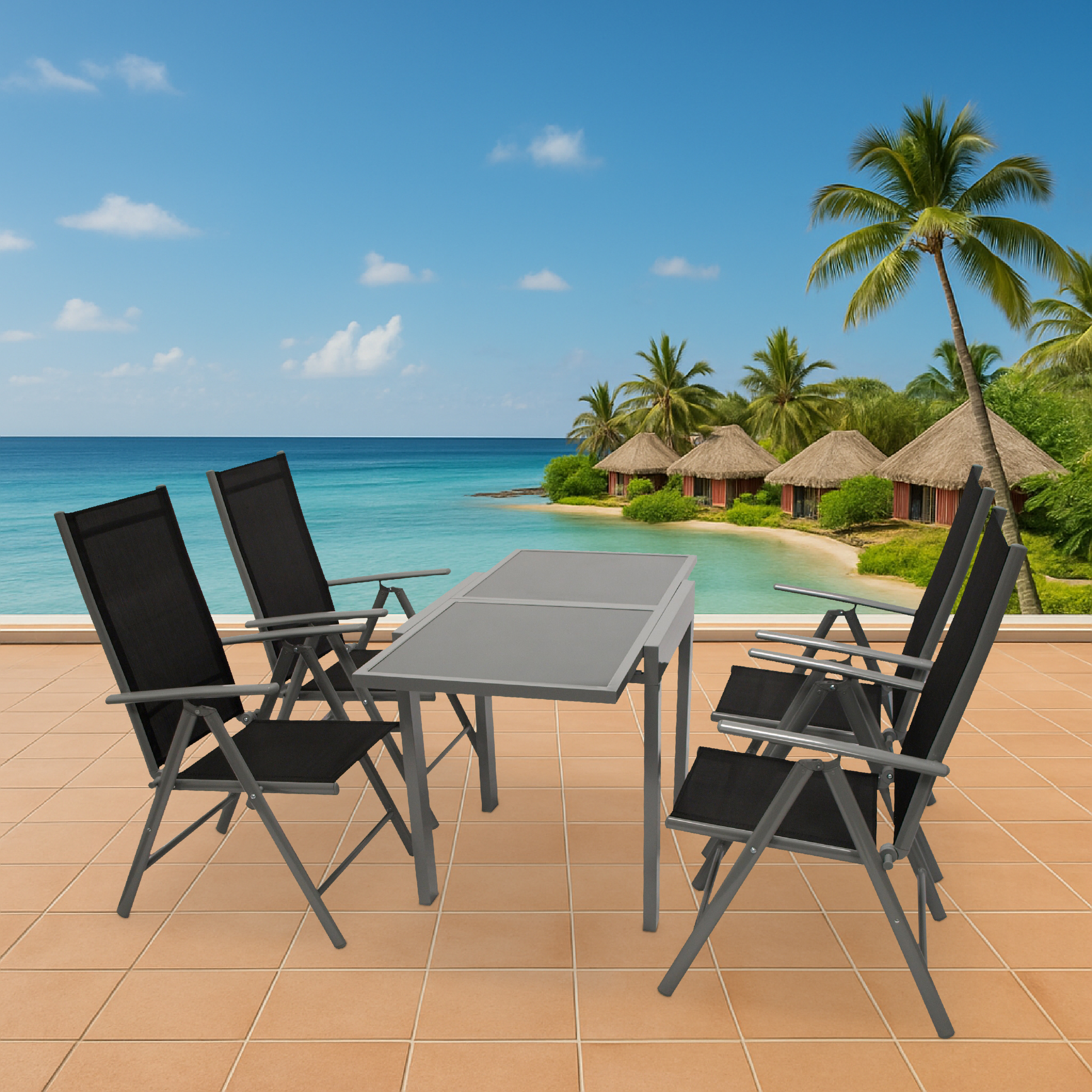 Gartentisch und Stühle am Strand mit Hütten und Palmen im Hintergrund.
