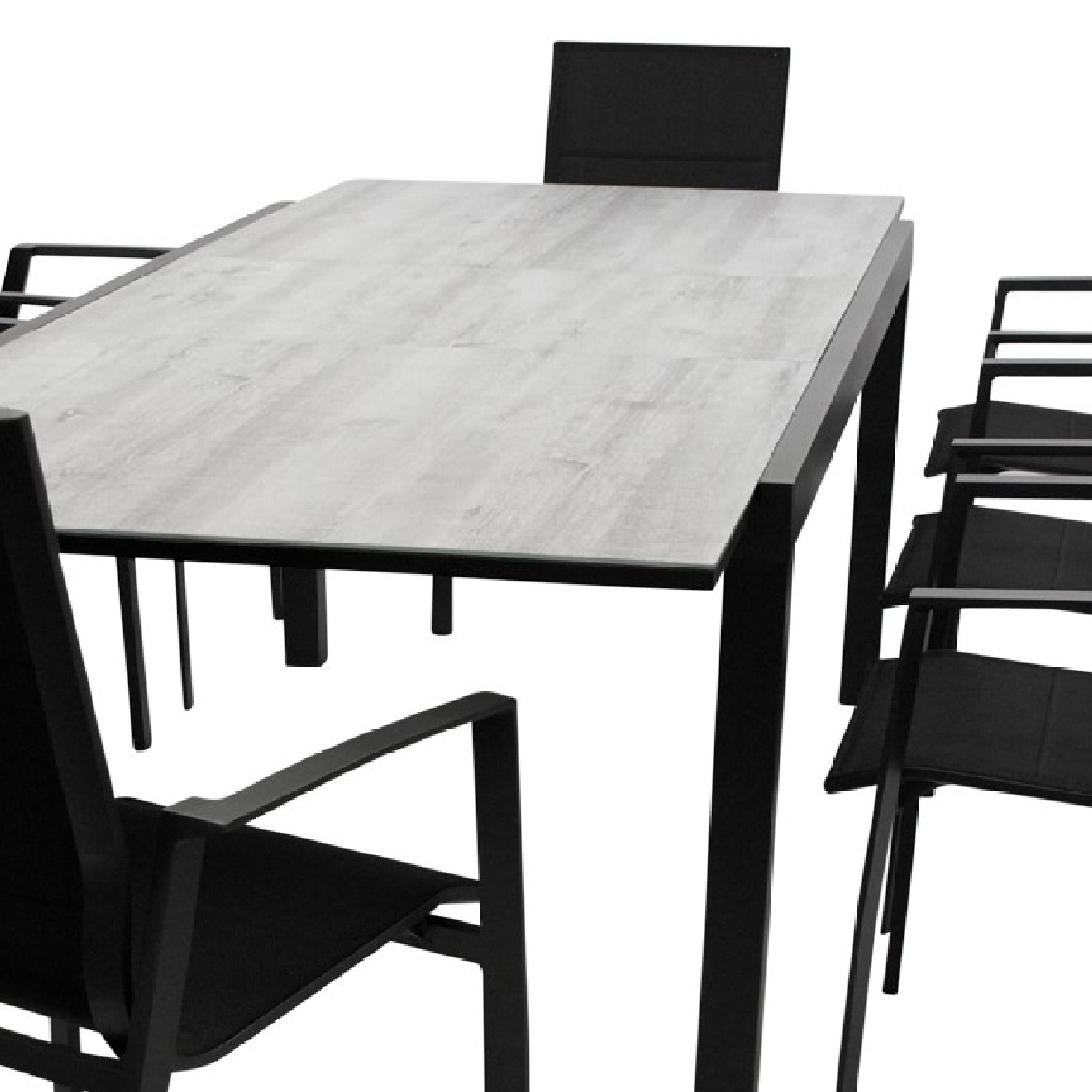 Ein rechteckiger Tisch mit grauer Platte und schwarzem Metallgestell, umgeben von schwarzen Stühlen.