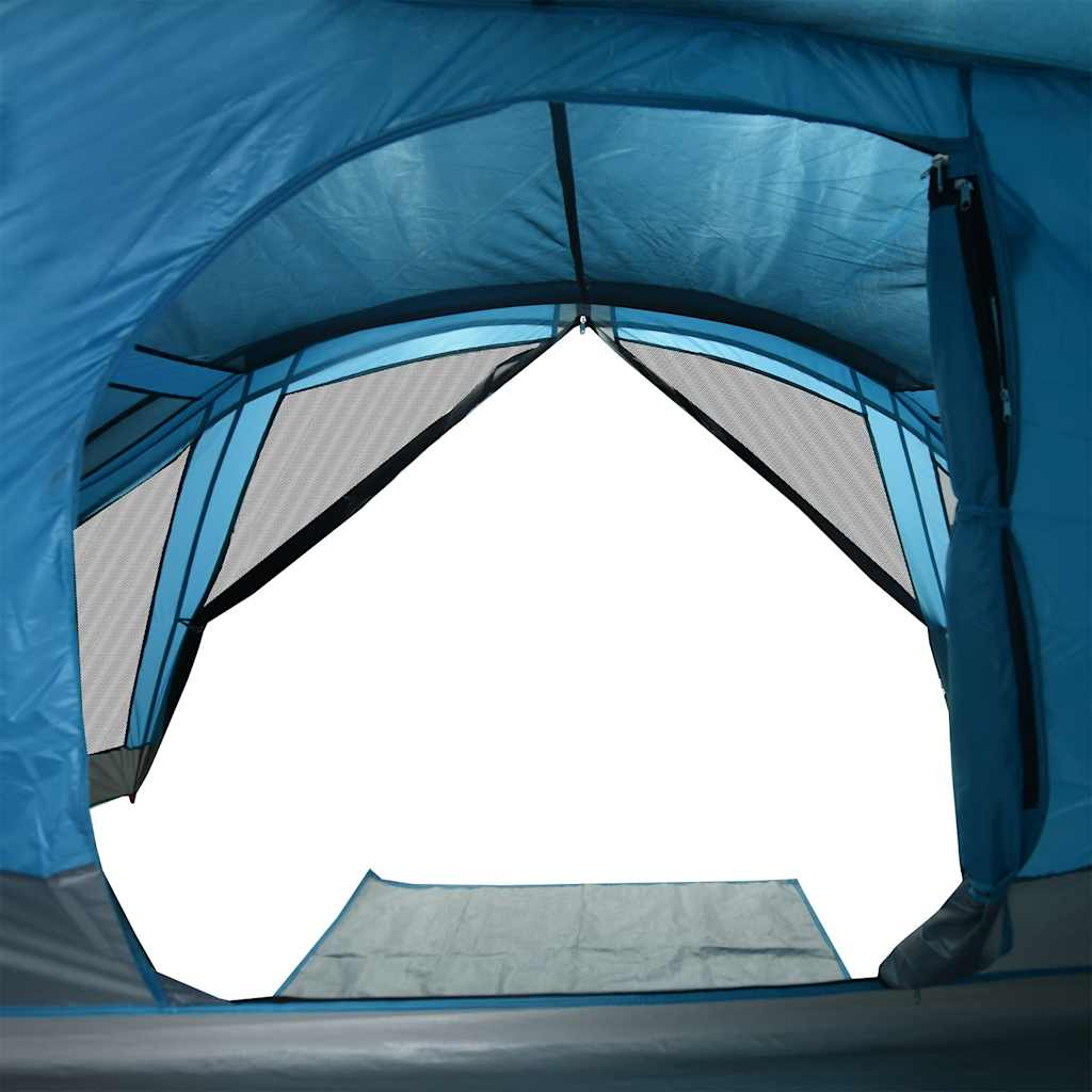 Blick aus einem blauen Zelt, mit Netzfenstern und einer grauen Bodenmatte.