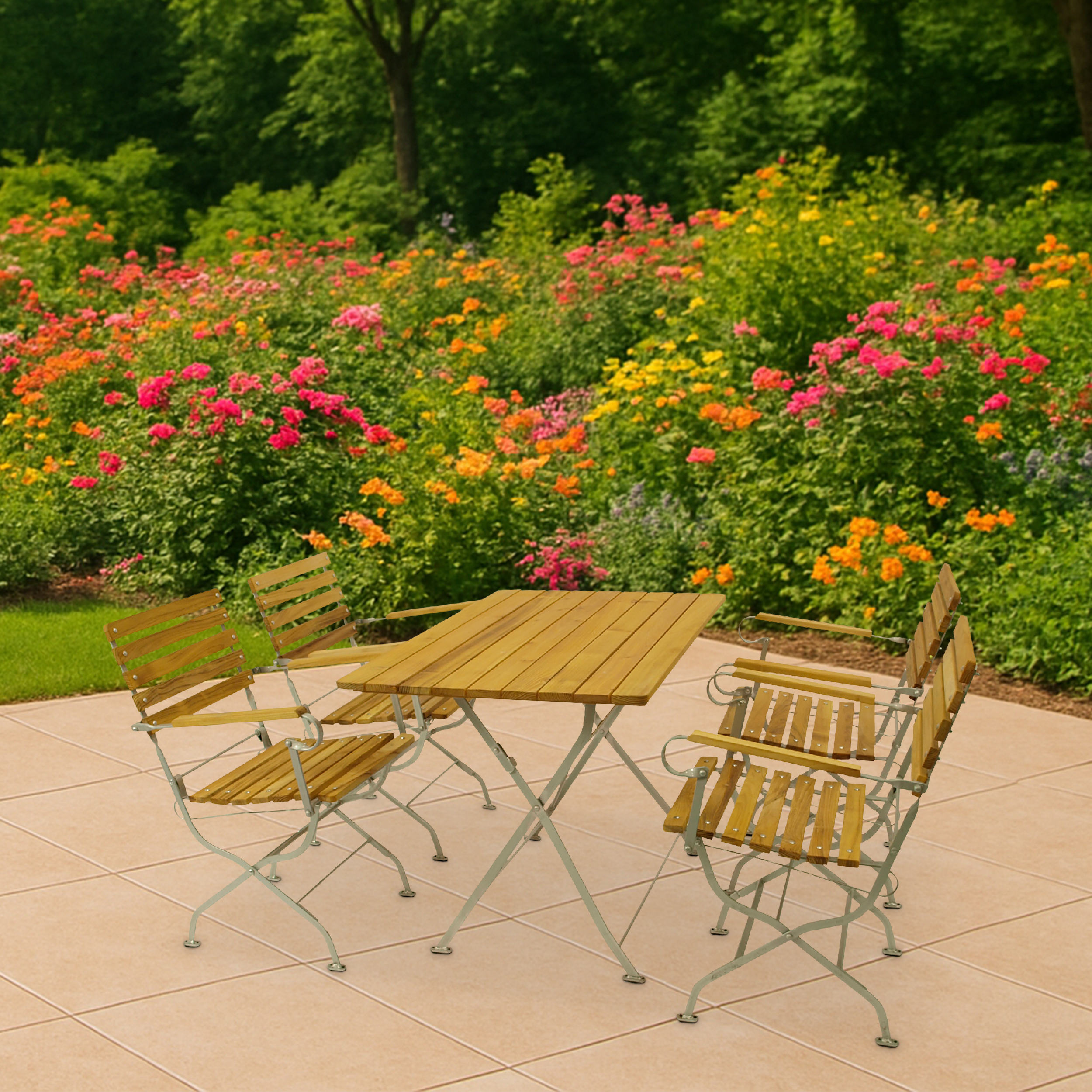 Holztisch und Stühle auf einer Terrasse vor einem blühenden Blumenbeet.