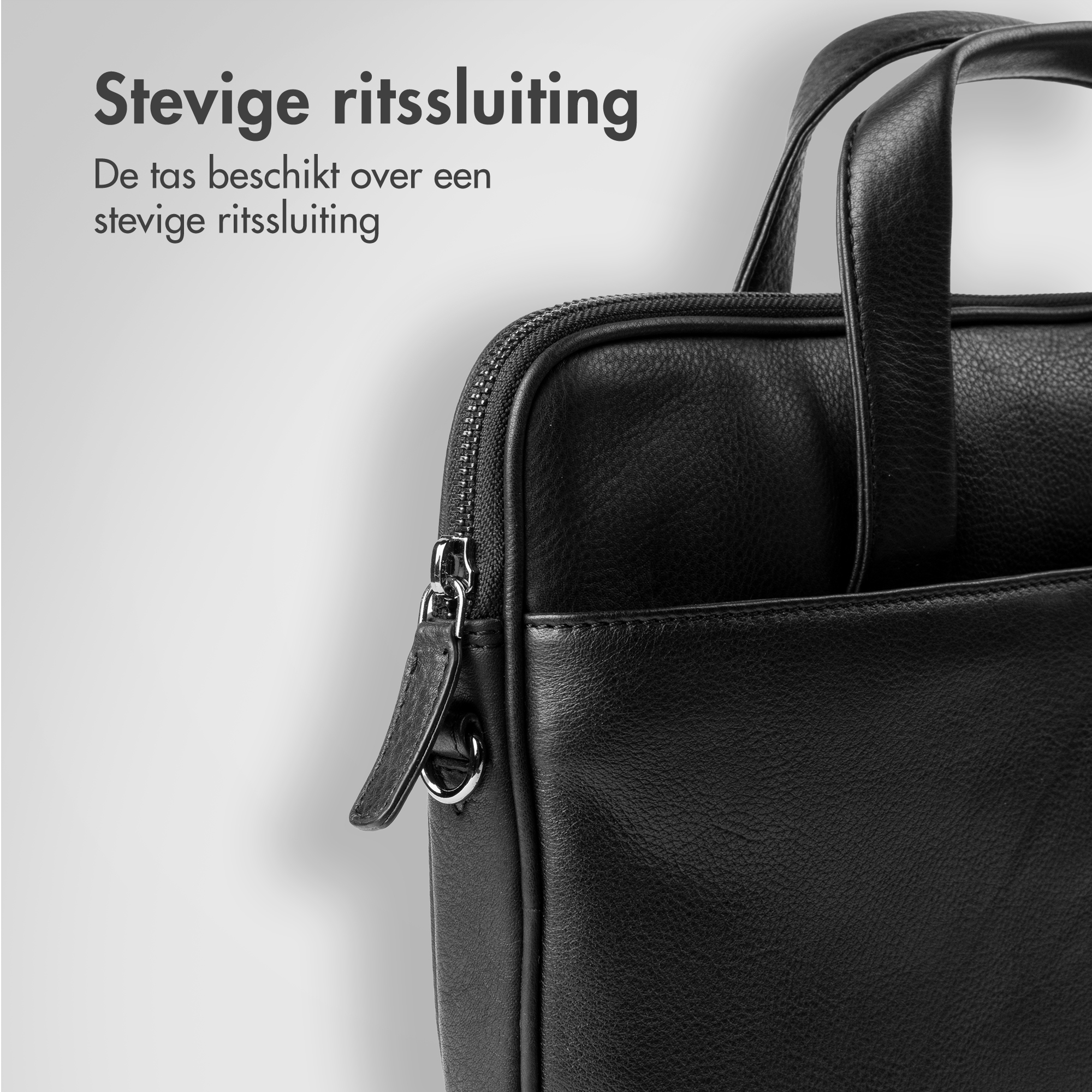 Black leather bag with zipper and handles, close-up view.