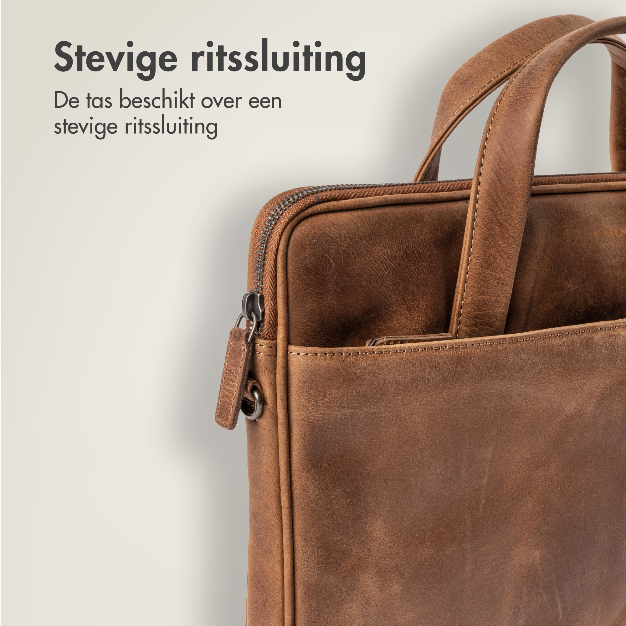 Close-up of a brown leather bag with a zipper and handles.