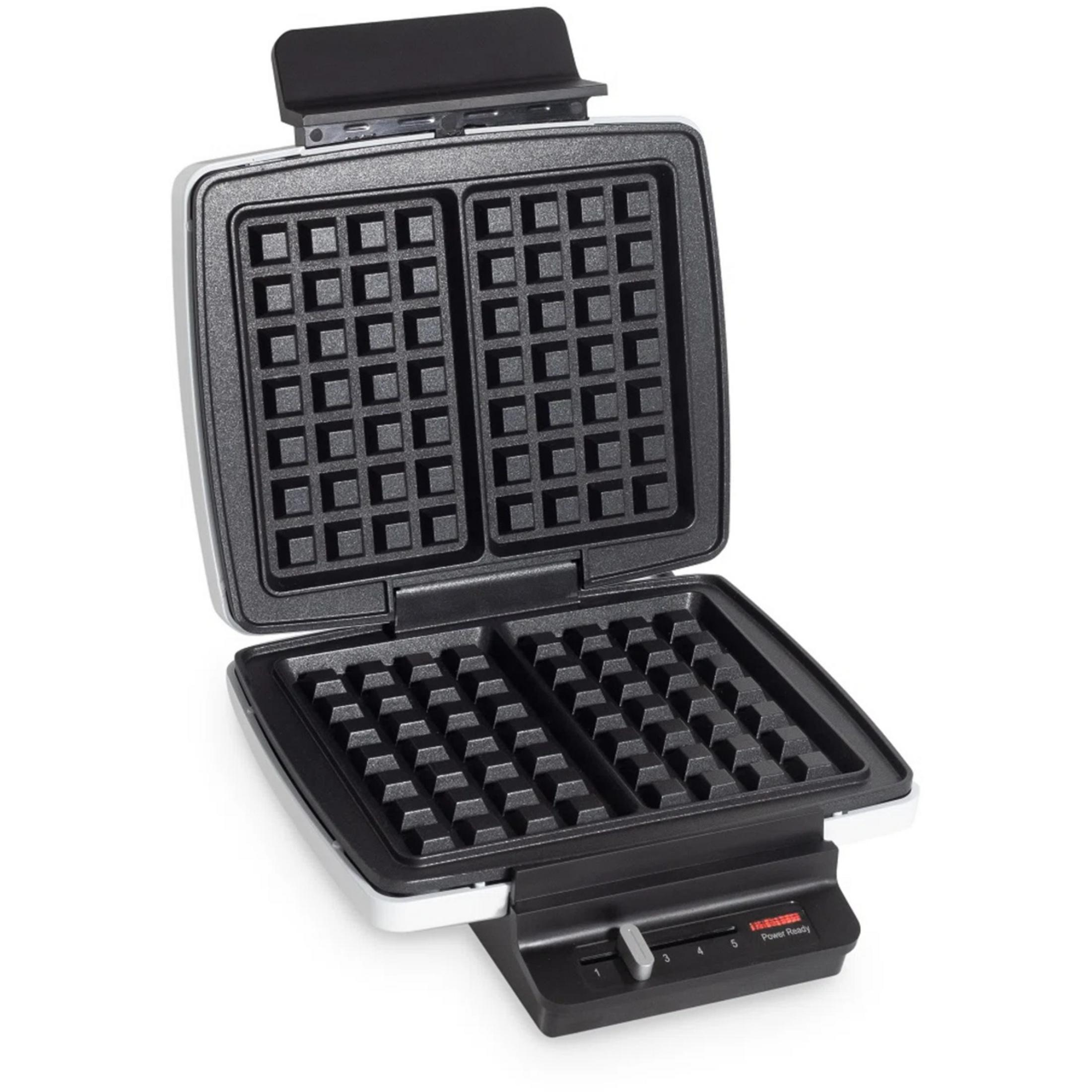 Open waffle maker with black non-stick coating and white housing.