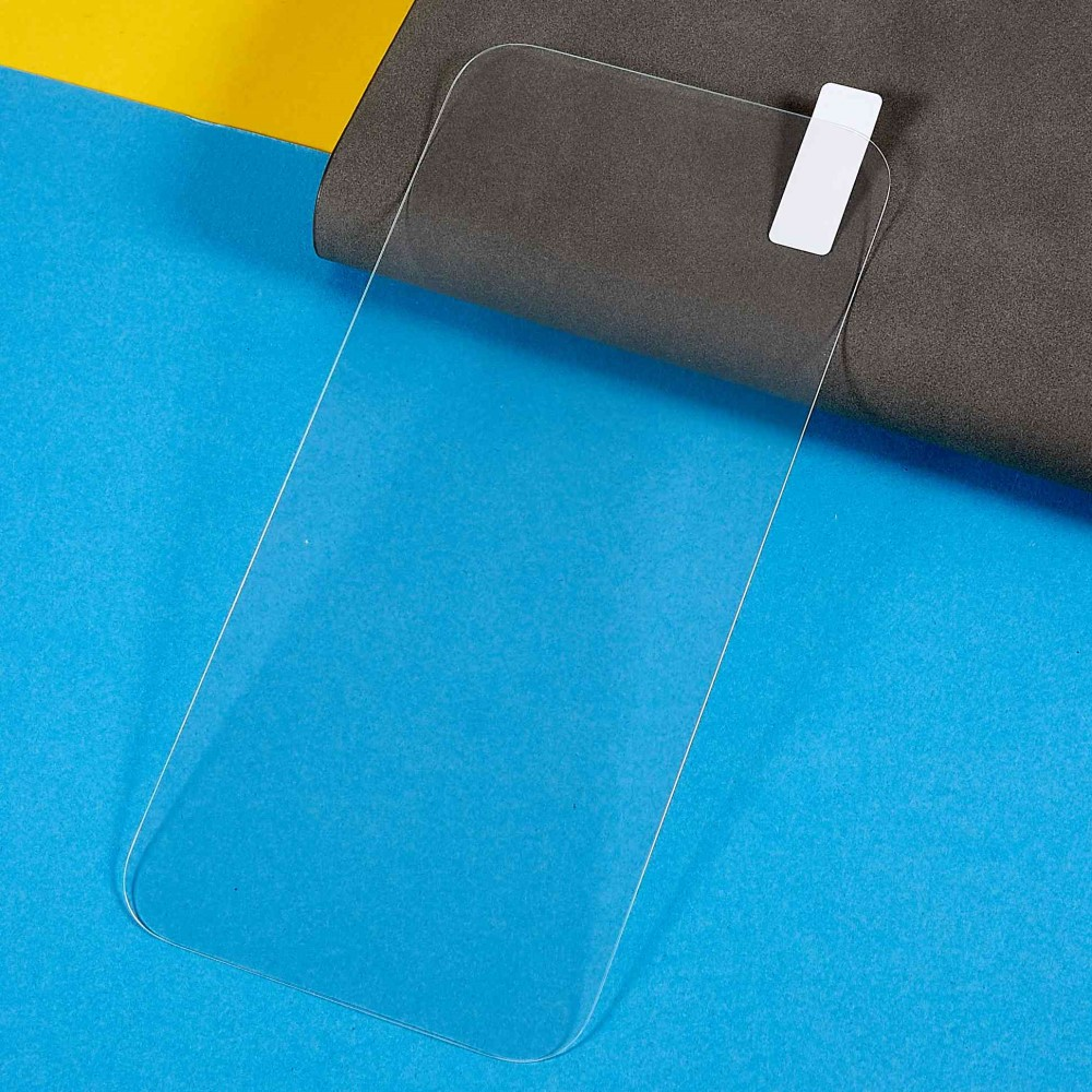 Ein klares Displayschutzglas mit einem weißen Aufkleber auf einer blauen und grauen Oberfläche.