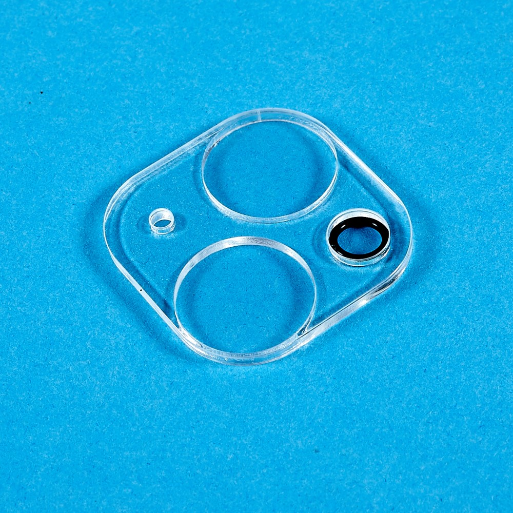 Protezione trasparente per obiettivo fotocamera telefono in plastica con tre ritagli circolari.