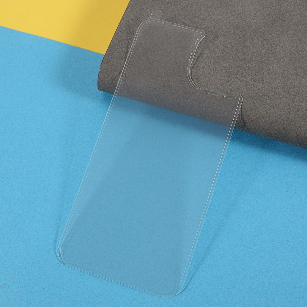 Una protezione schermo per telefono in plastica trasparente giace su una superficie blu e gialla.