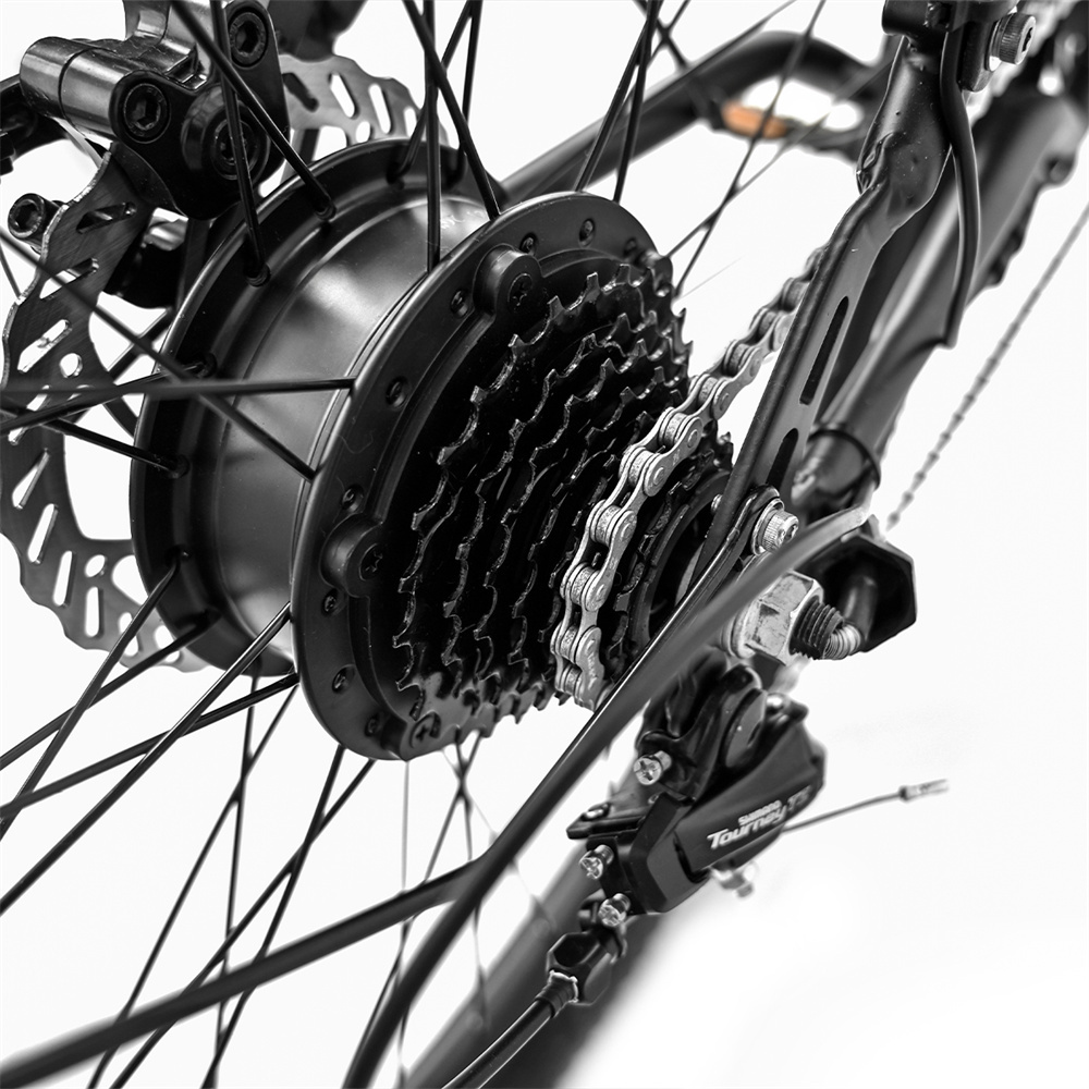 Primer plano del casete de engranajes trasero de una bicicleta, cadena y disco de freno.