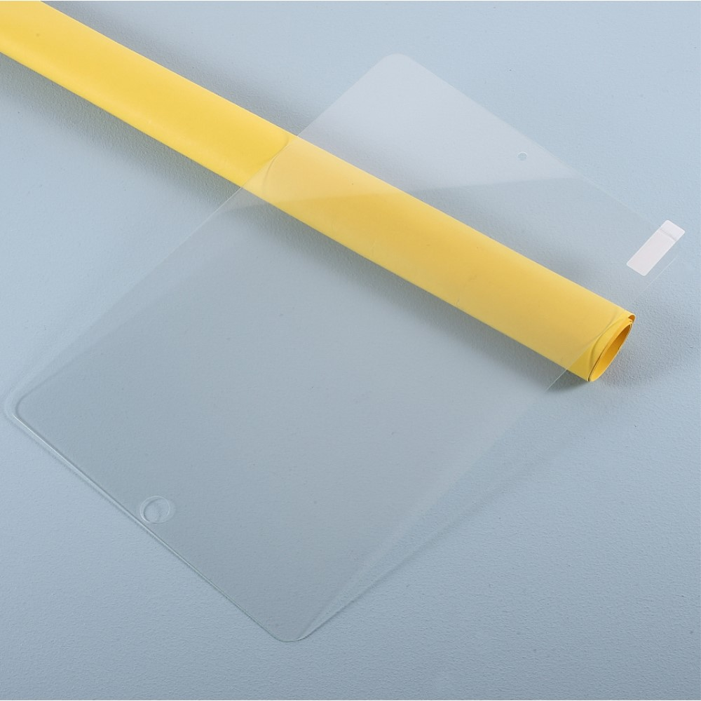 Un tube jaune repose sur un film protecteur transparent.