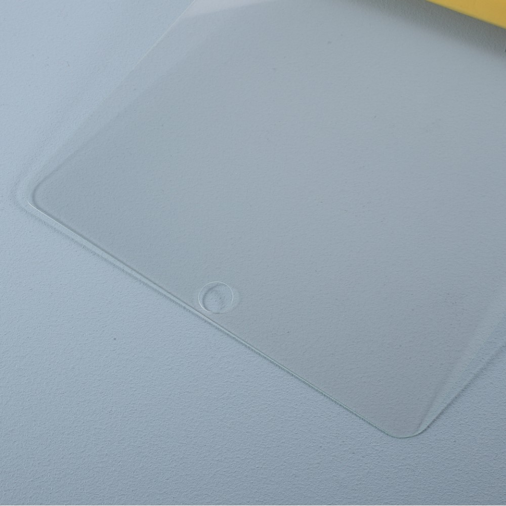Une feuille protectrice transparente avec un coin arrondi et une petite découpe circulaire est visible.