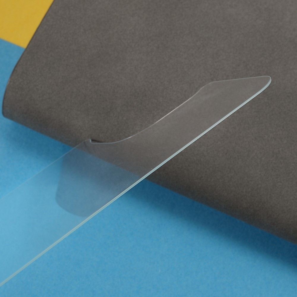 Un objet transparent repose sur une surface bleue et grise.