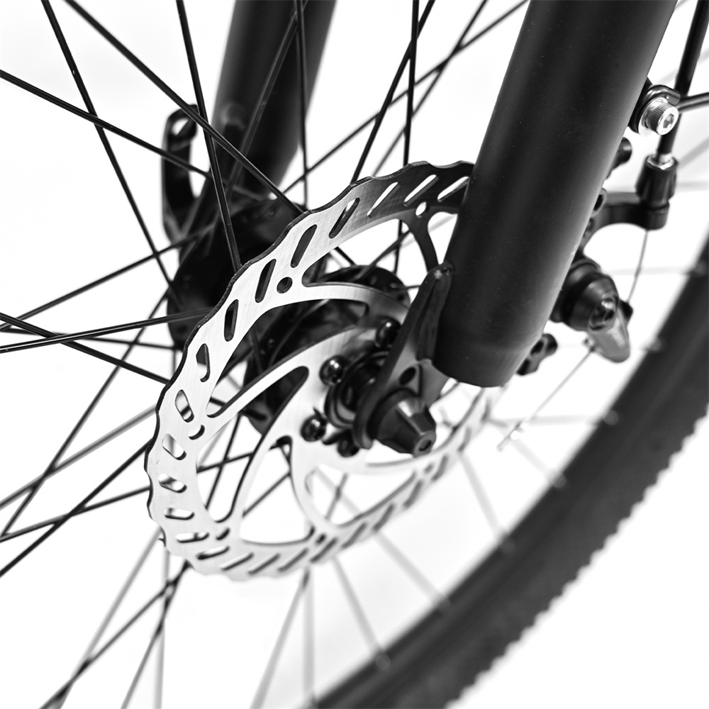 Primo piano del rotore del freno a disco anteriore di una bicicletta, raggi e forcella.