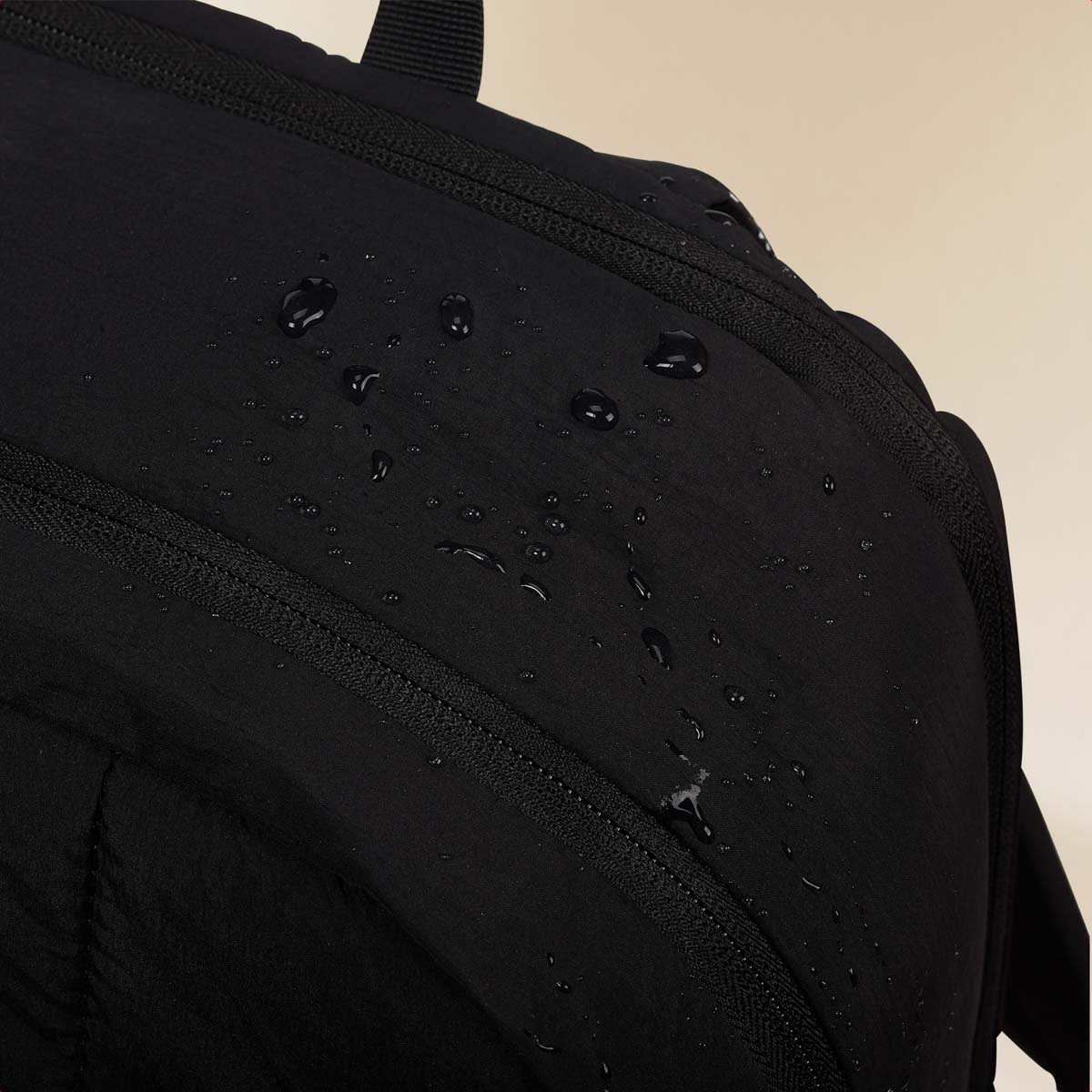 Water droplets on black fabric with zippers.