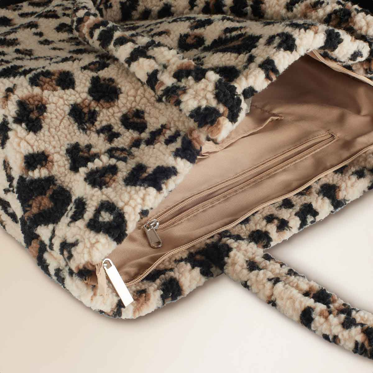 A fuzzy leopard print bag, open with zippers and a handle.