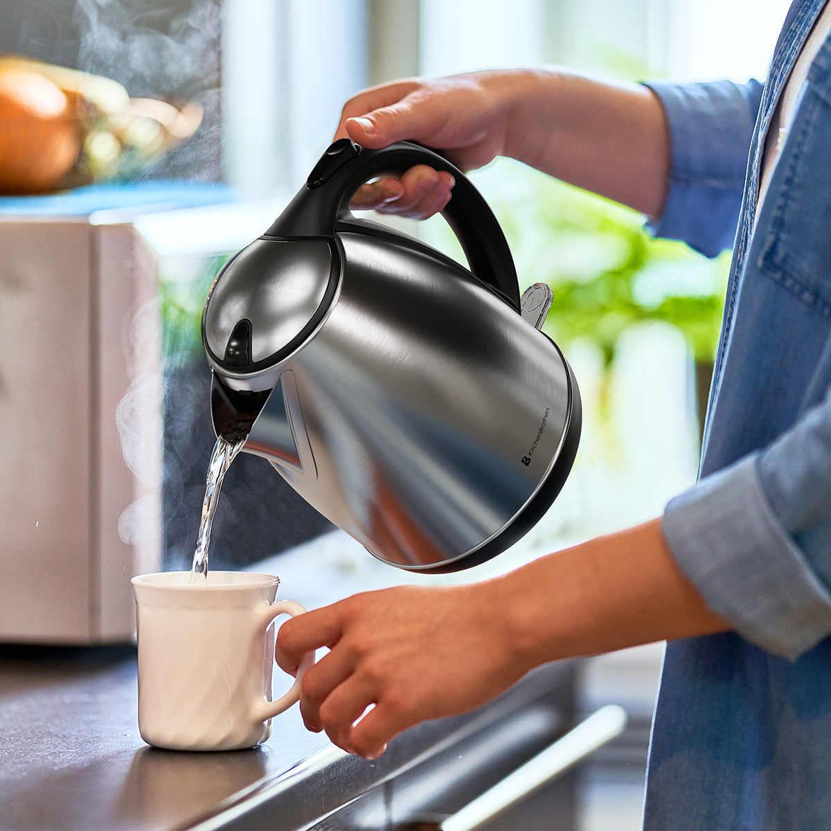 Een hand giet heet water uit een waterkoker in een witte mok. Stoom.
