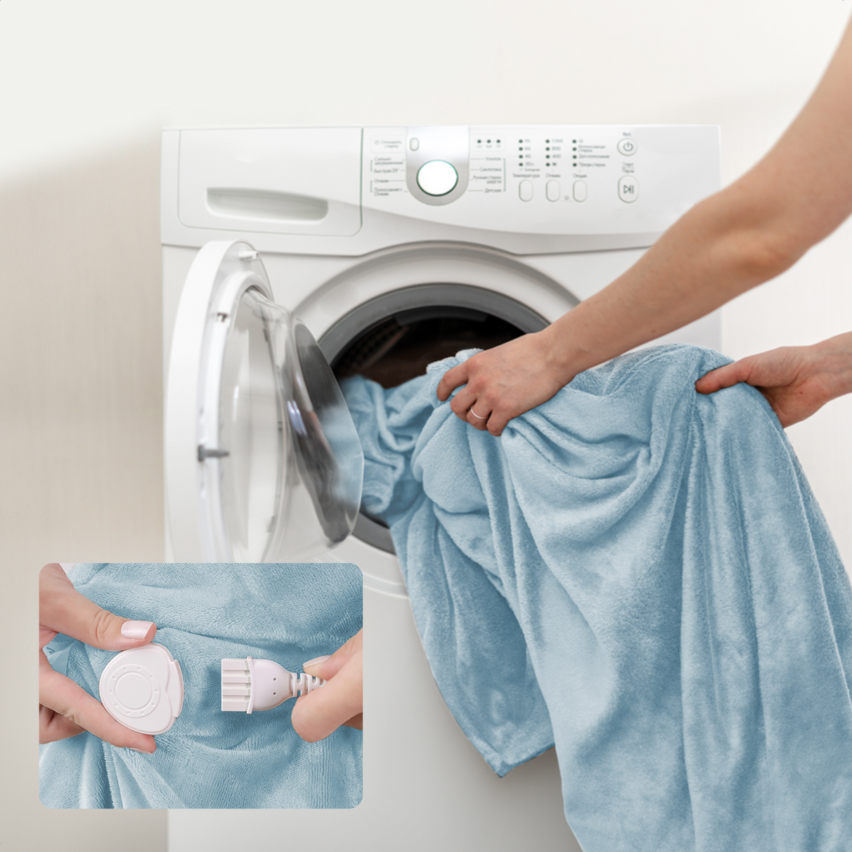 A person puts a blue blanket into a white washing machine.
