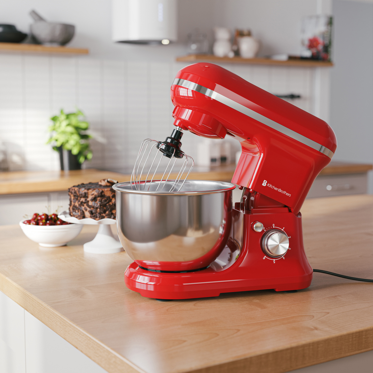 Een rode standmixer met garde staat op een houten aanrecht naast een chocoladetaart.