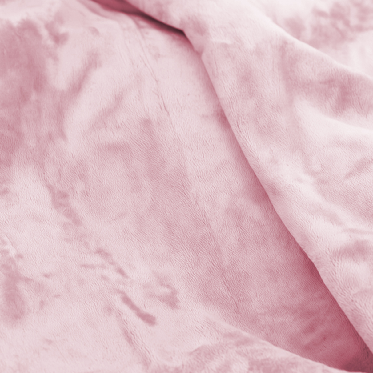 A soft, light pink, textured fabric is draped, creating gentle folds and shadows.