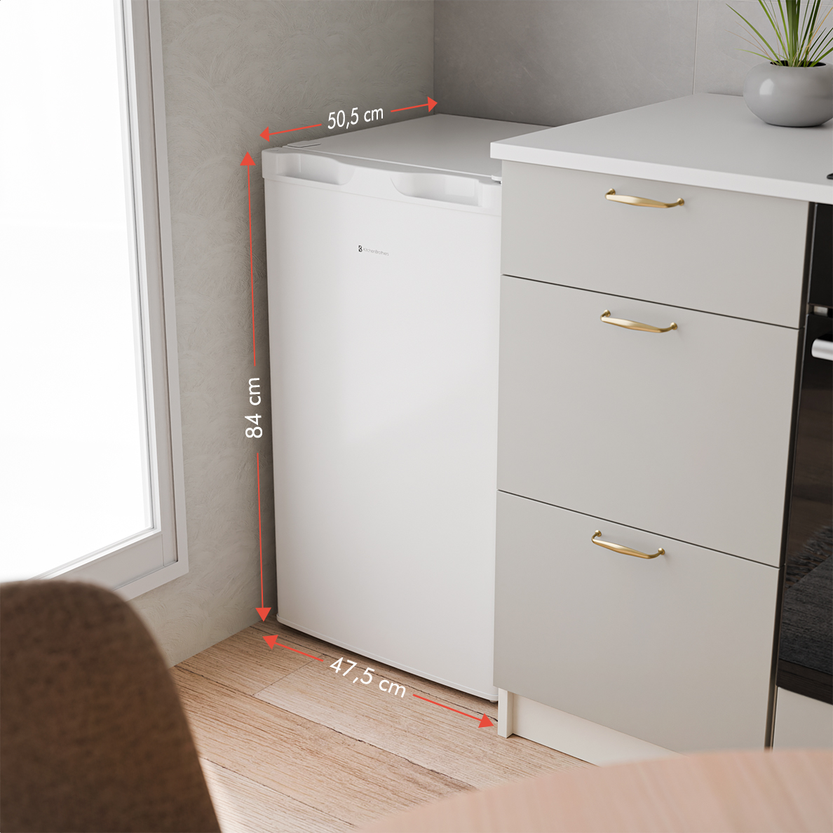 White refrigerator-freezer measuring 50.5x84x47.5 cm next to grey drawers.