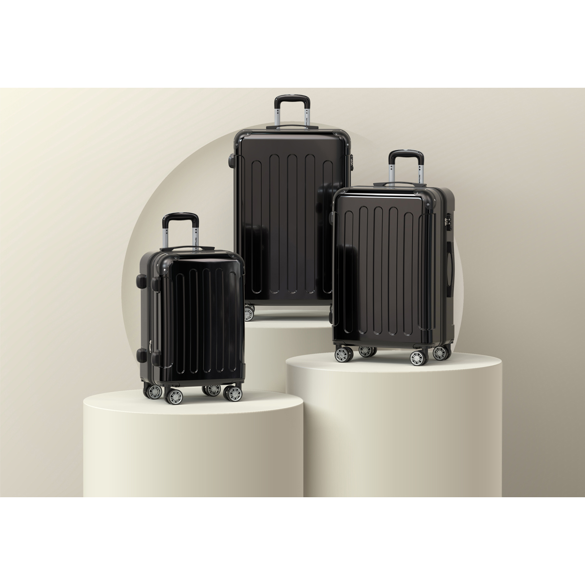 Trois valises noires de tailles variées sur des piédestaux crème.
