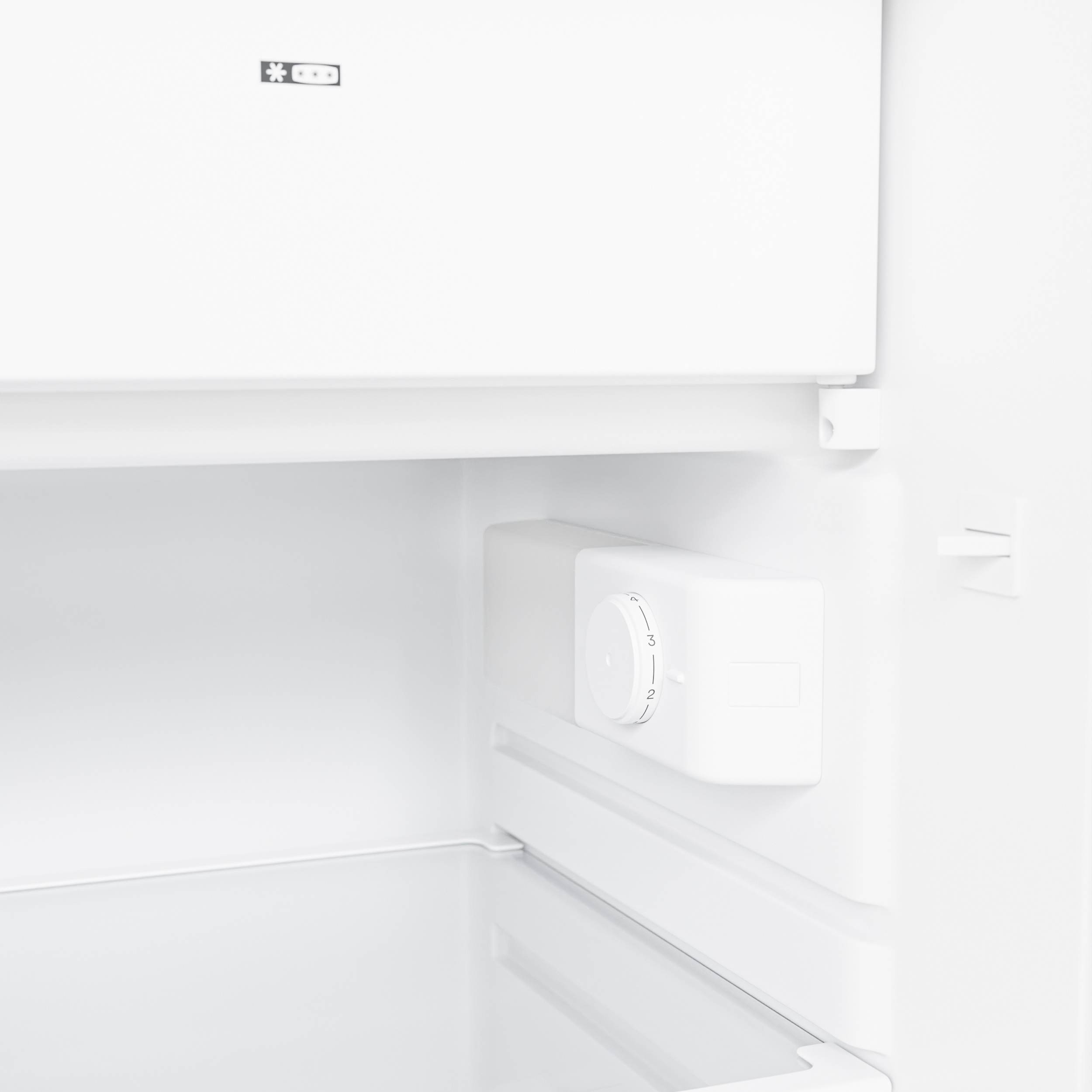 Intérieur d'un réfrigérateur blanc avec cadran de température et symbole flocon de neige.