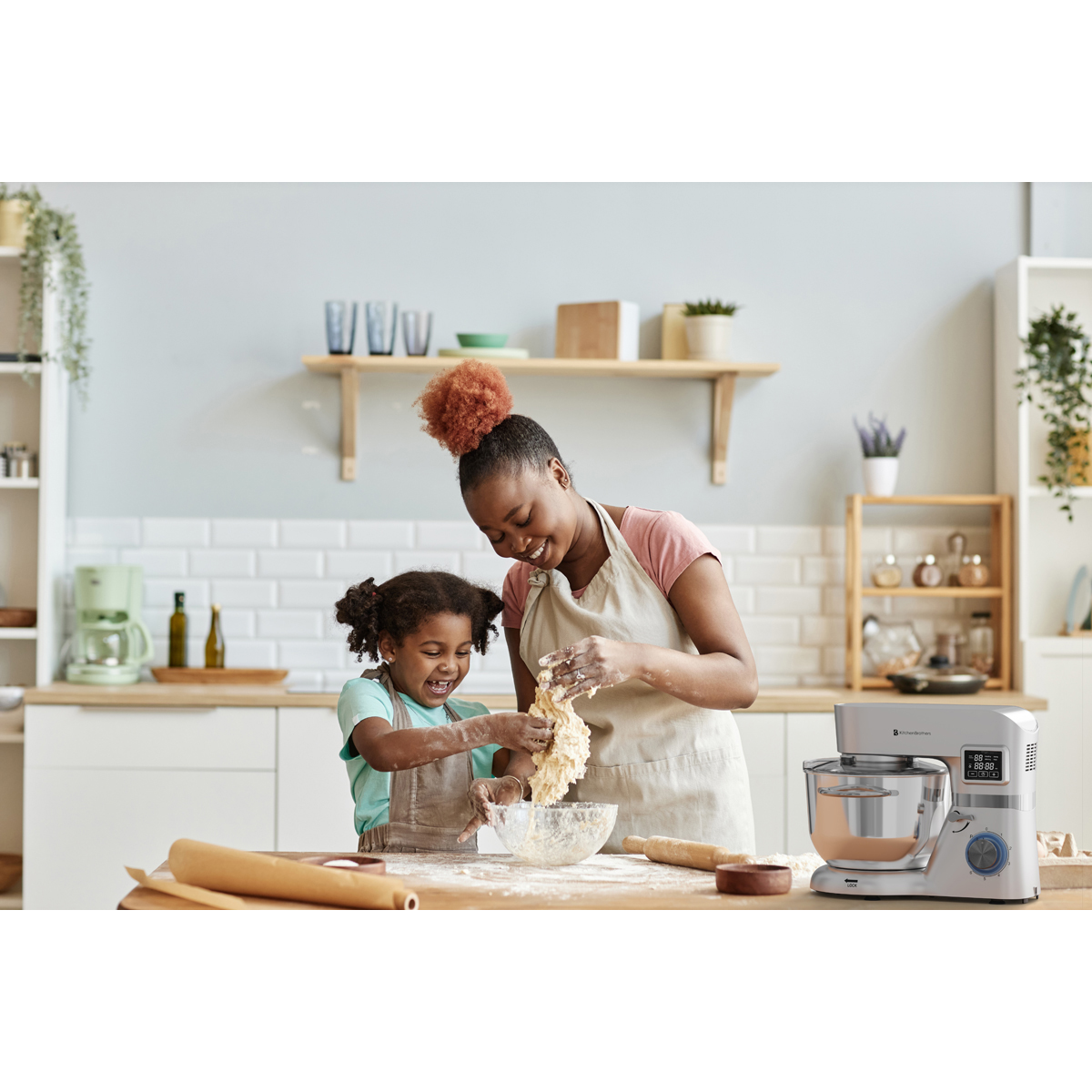 Moeder en kind kneden deeg in een keuken met een keukenmachine.