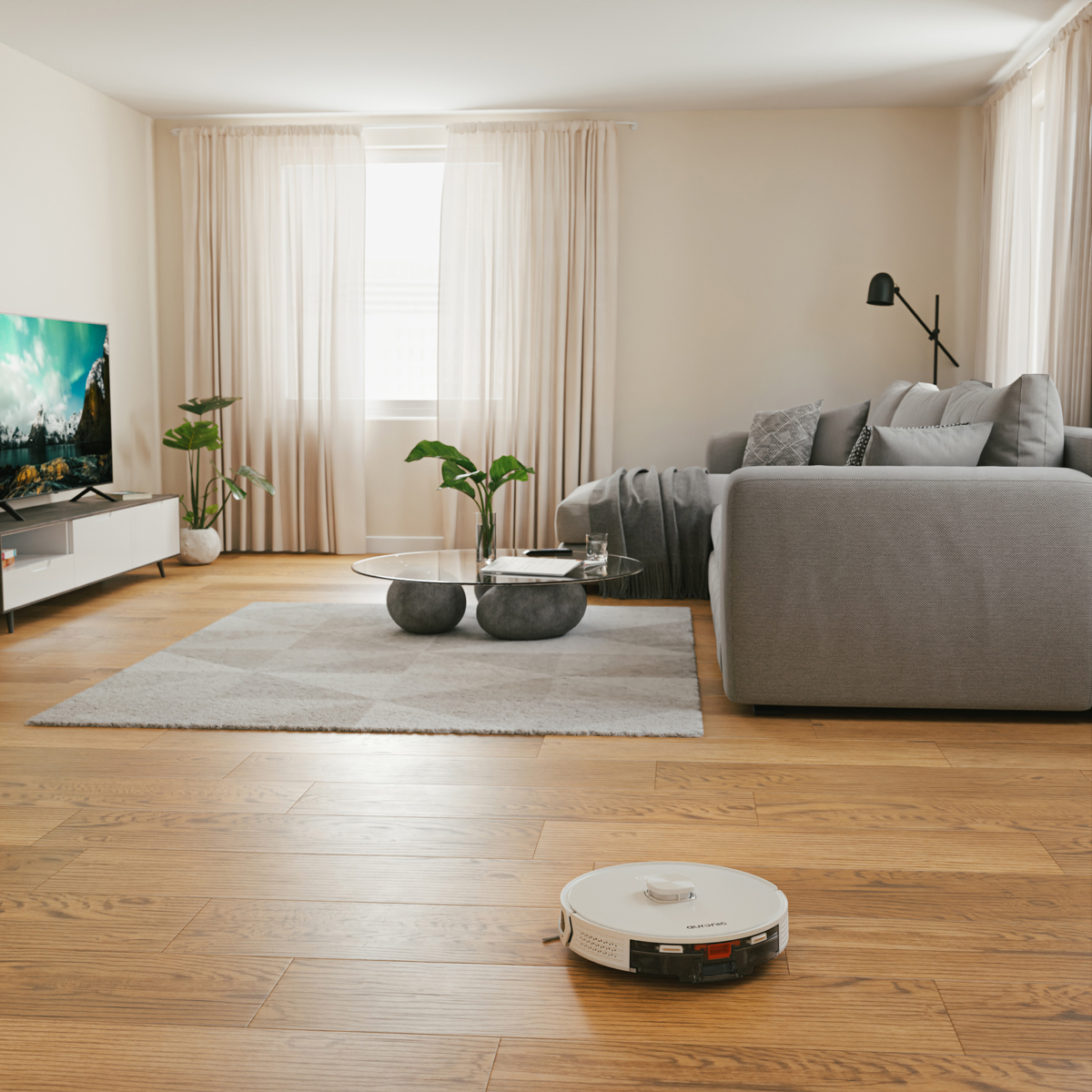 Ein weißer Saugroboter reinigt einen Holzboden in einem Wohnzimmer mit Sofa.