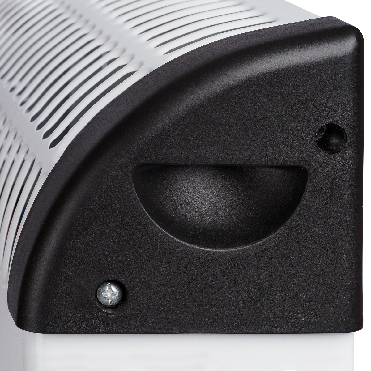 Close-up van een wit en zwart apparaat met een gebogen bovenkant en ventilatiesleuven.