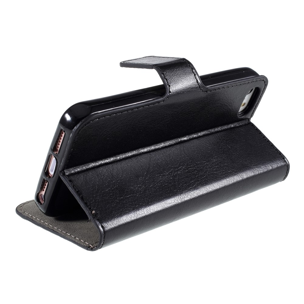 Étui portefeuille en cuir noir avec un téléphone à l'intérieur, sur fond blanc.