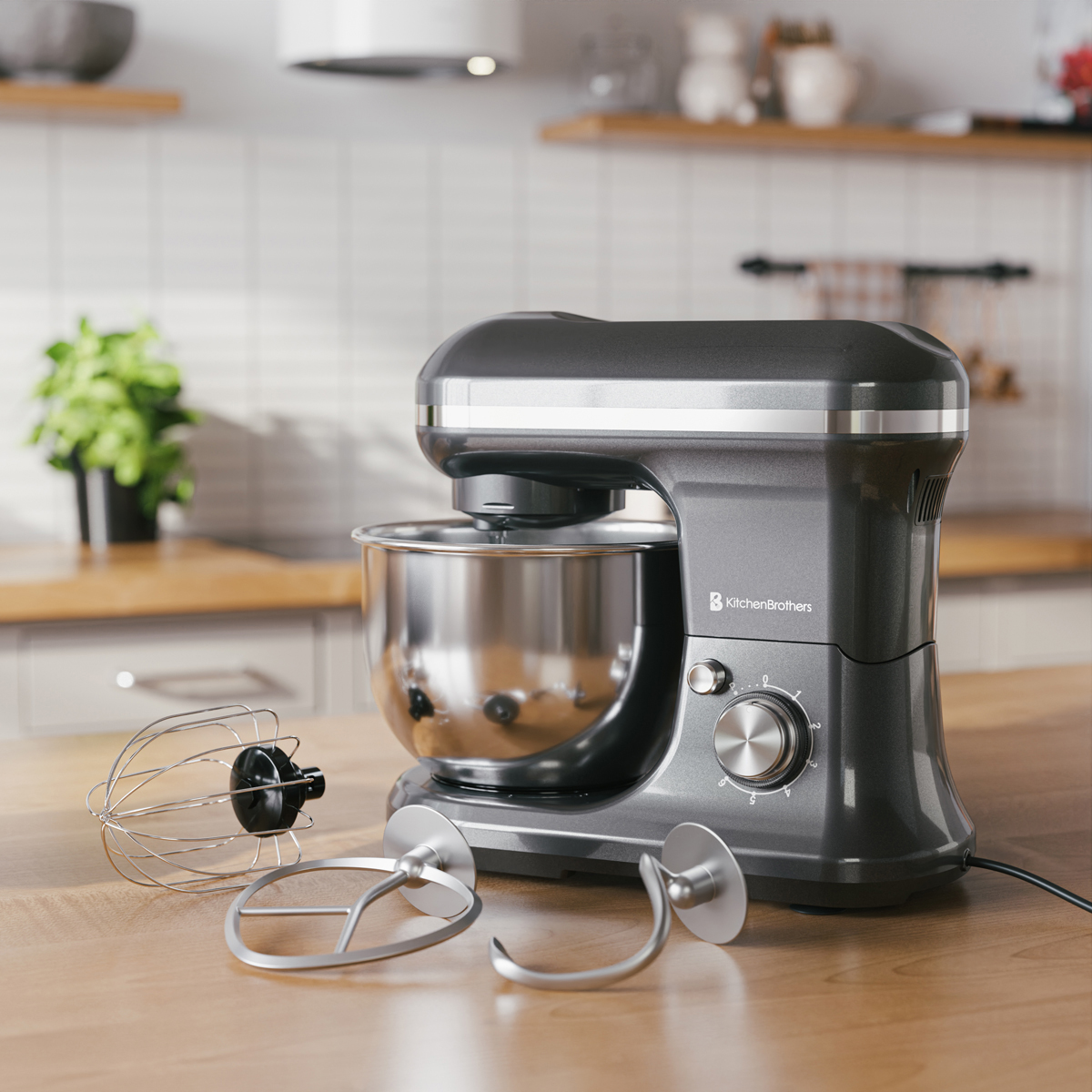 Un robot pâtissier gris avec bol inox et accessoires sur une table en bois.