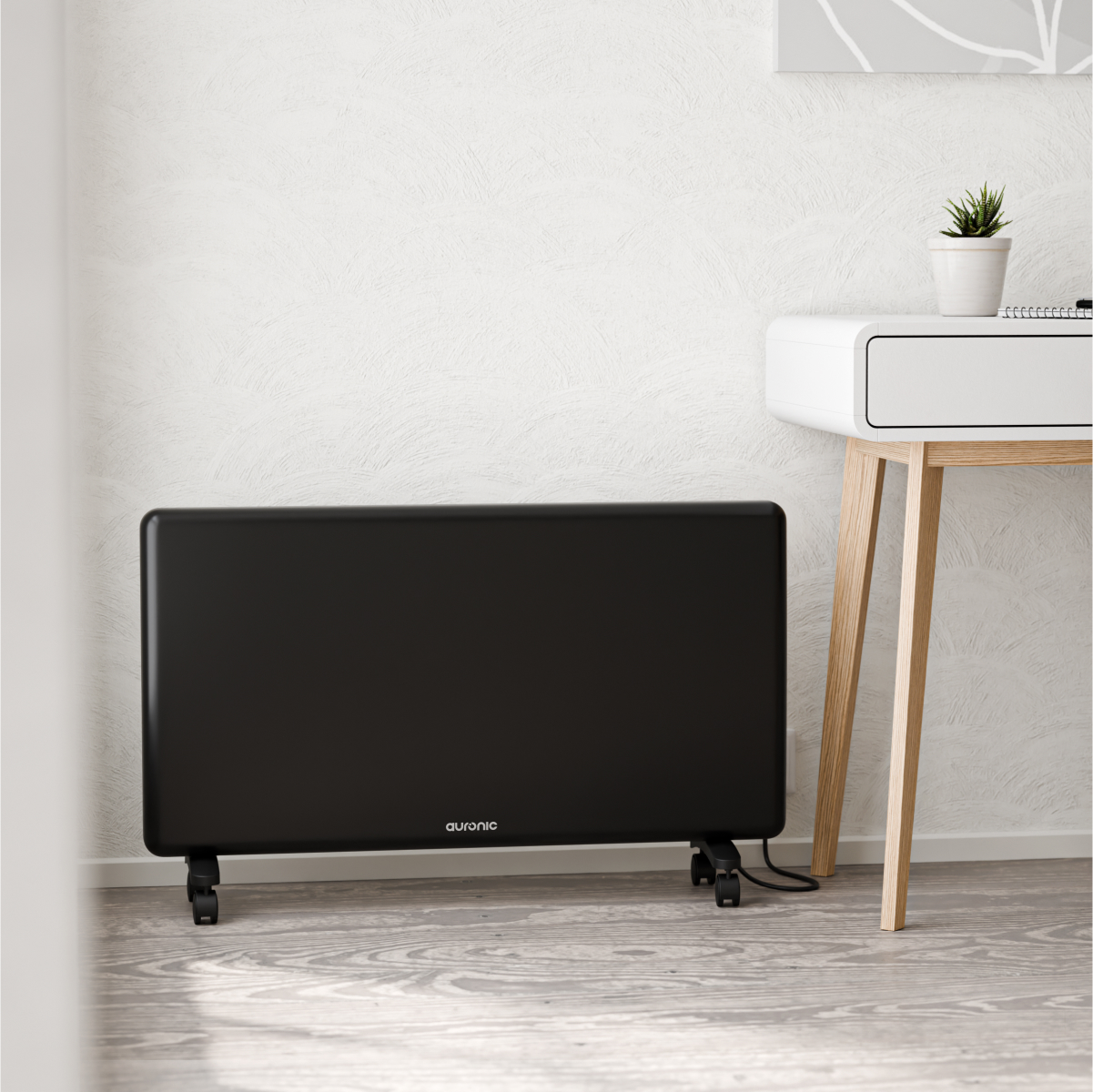 A black radiator with wheels sits on a wooden floor next to a white desk.