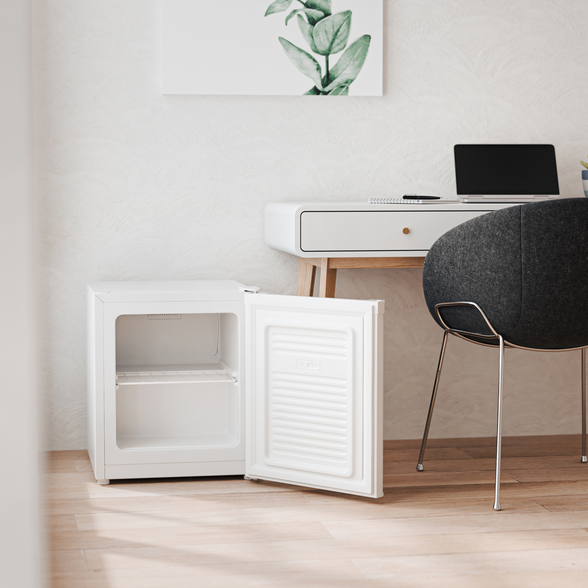 A white mini-fridge with its door open stands on a wooden floor, next to a desk.