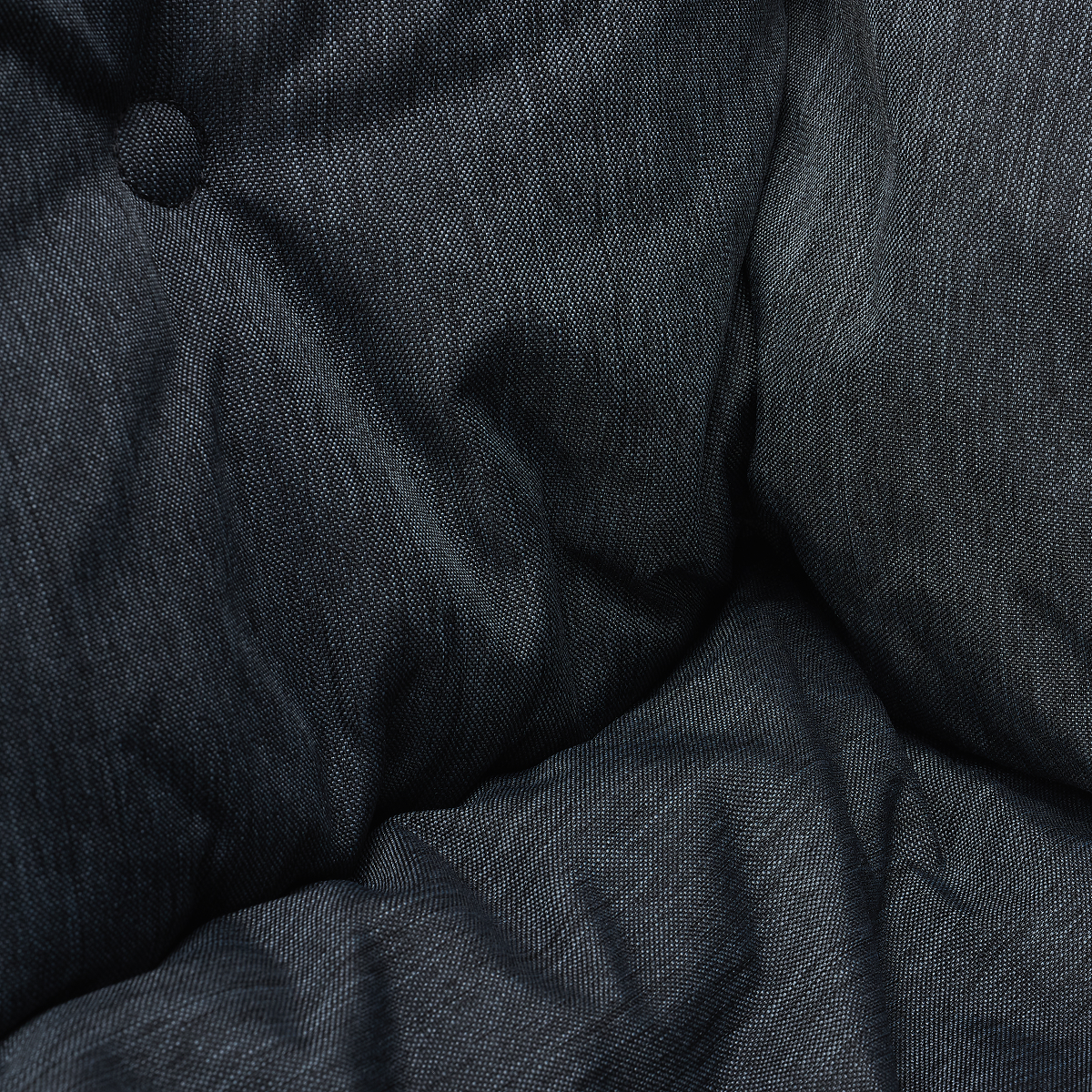 Dark grey textured fabric cushion with button detail and folds.