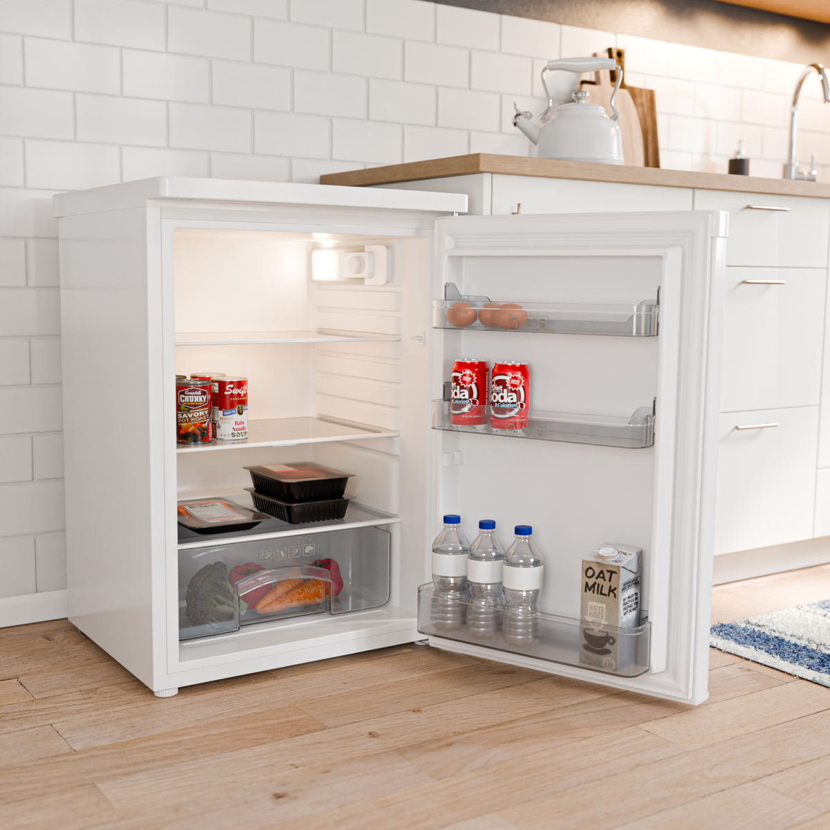 Un réfrigérateur blanc ouvert contient des œufs, des canettes et des bouteilles.