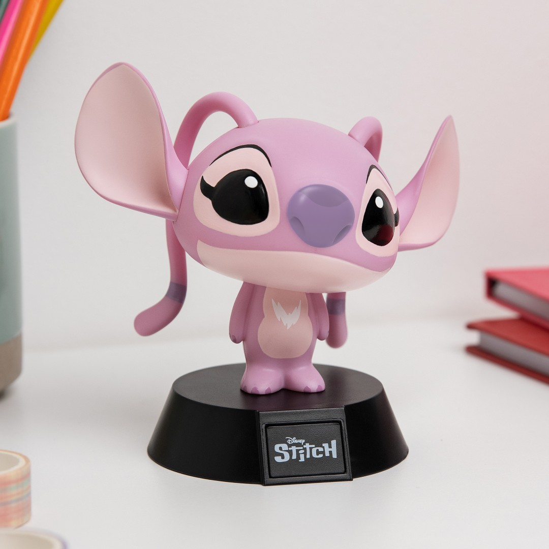 Różowa figurka Stitcha z dużymi uszami stoi na czarnej podstawie z logo Disney.