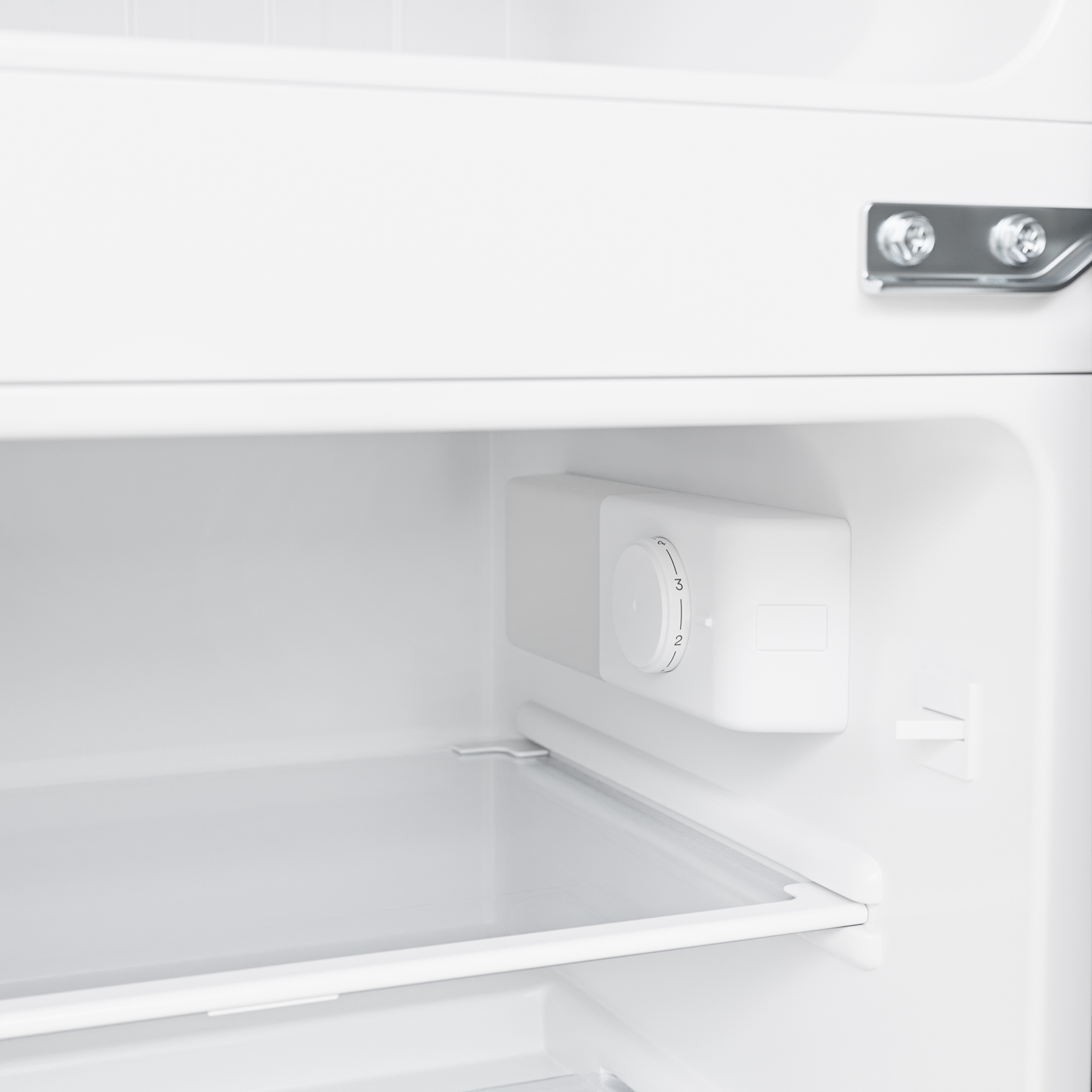 Intérieur d'un réfrigérateur blanc avec un cadran de contrôle de température.