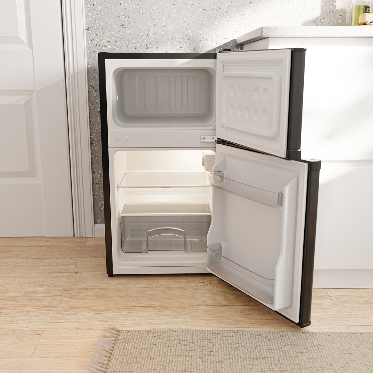 Un mini-frigo noir ouvert et vide avec des étagères et un tiroir. La porte est entrouverte.