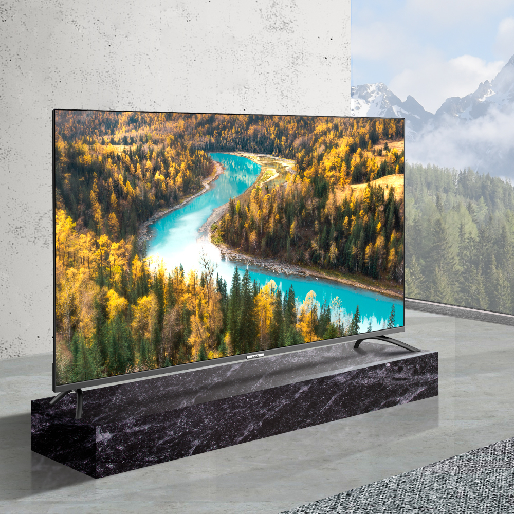 A modern TV displays a river flowing through a colorful forest, with mountains in background.