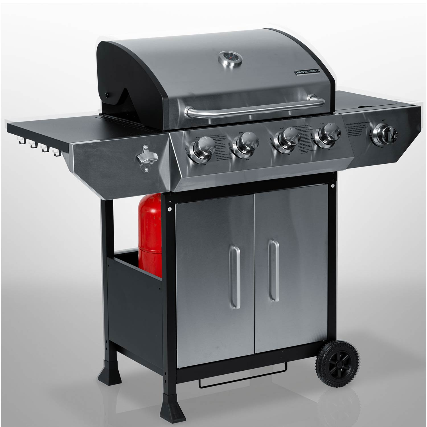 Srebrny grill gazowy z czarną podstawą, czerwoną butlą gazową i bocznymi półkami.
