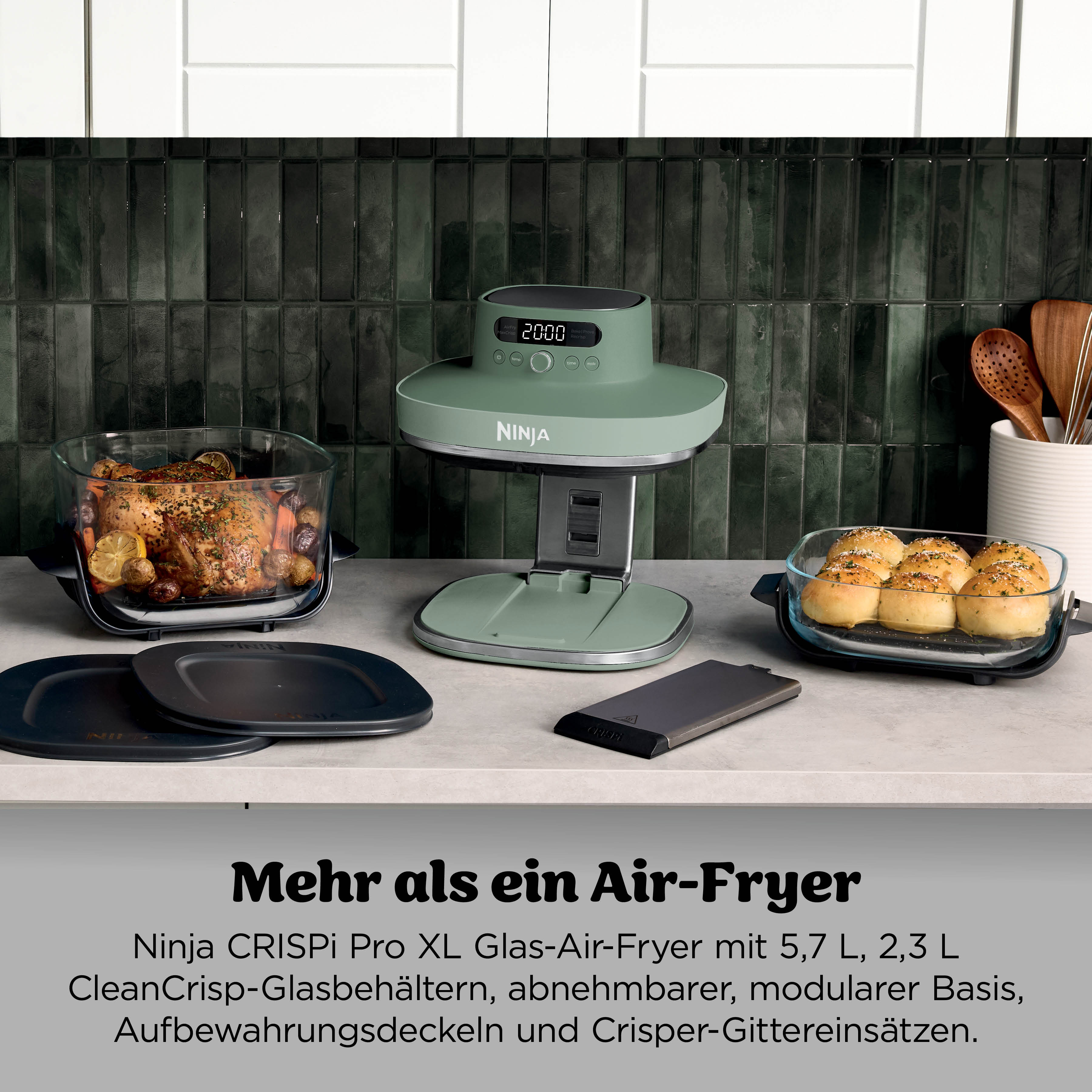 Ein Ninja Air-Fryer mit Hähnchen, Brötchen und Zubehör auf einer Arbeitsplatte.