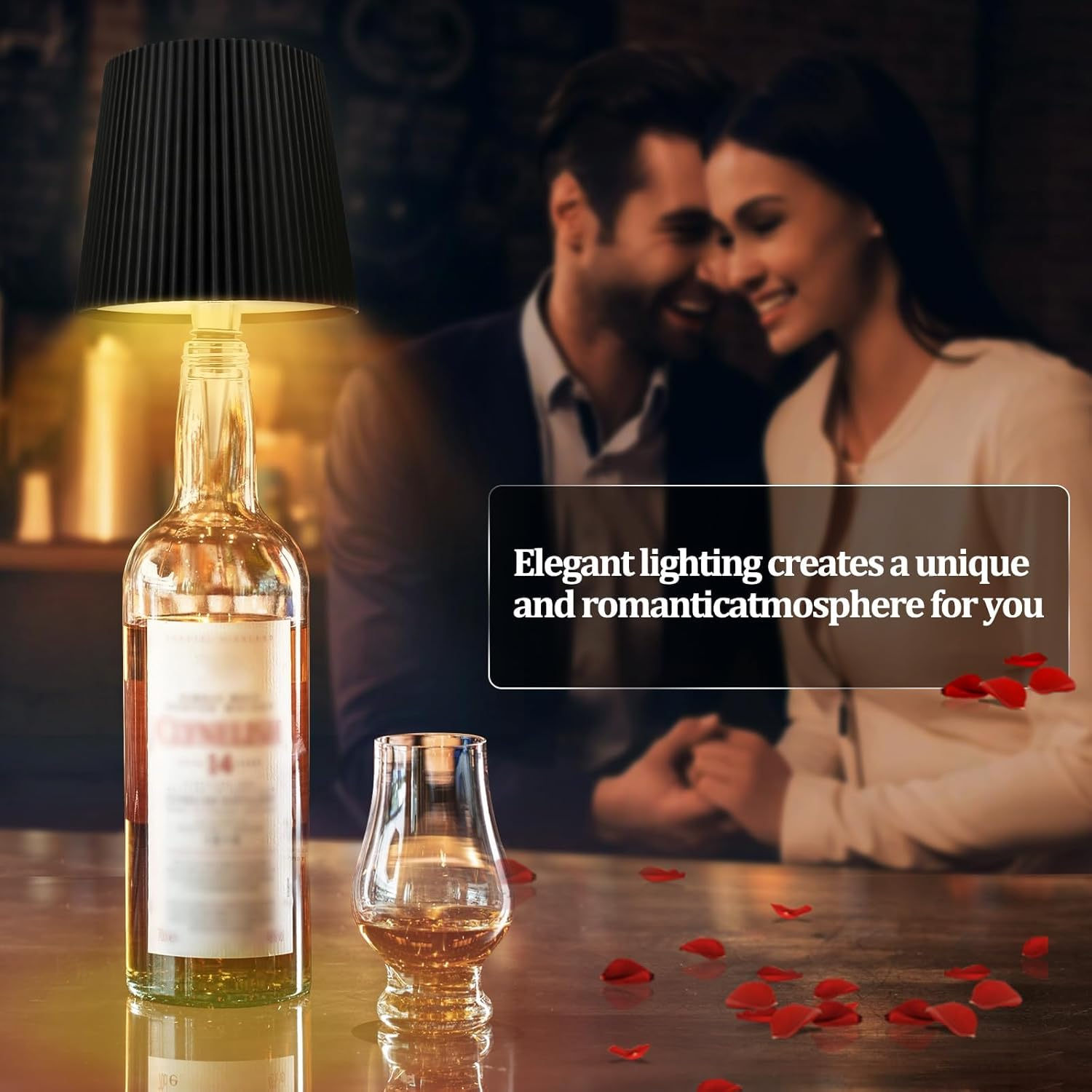 Eine Lampe aus einer Flasche mit einem Paar im Hintergrund. Rosenblätter liegen auf dem Tisch.