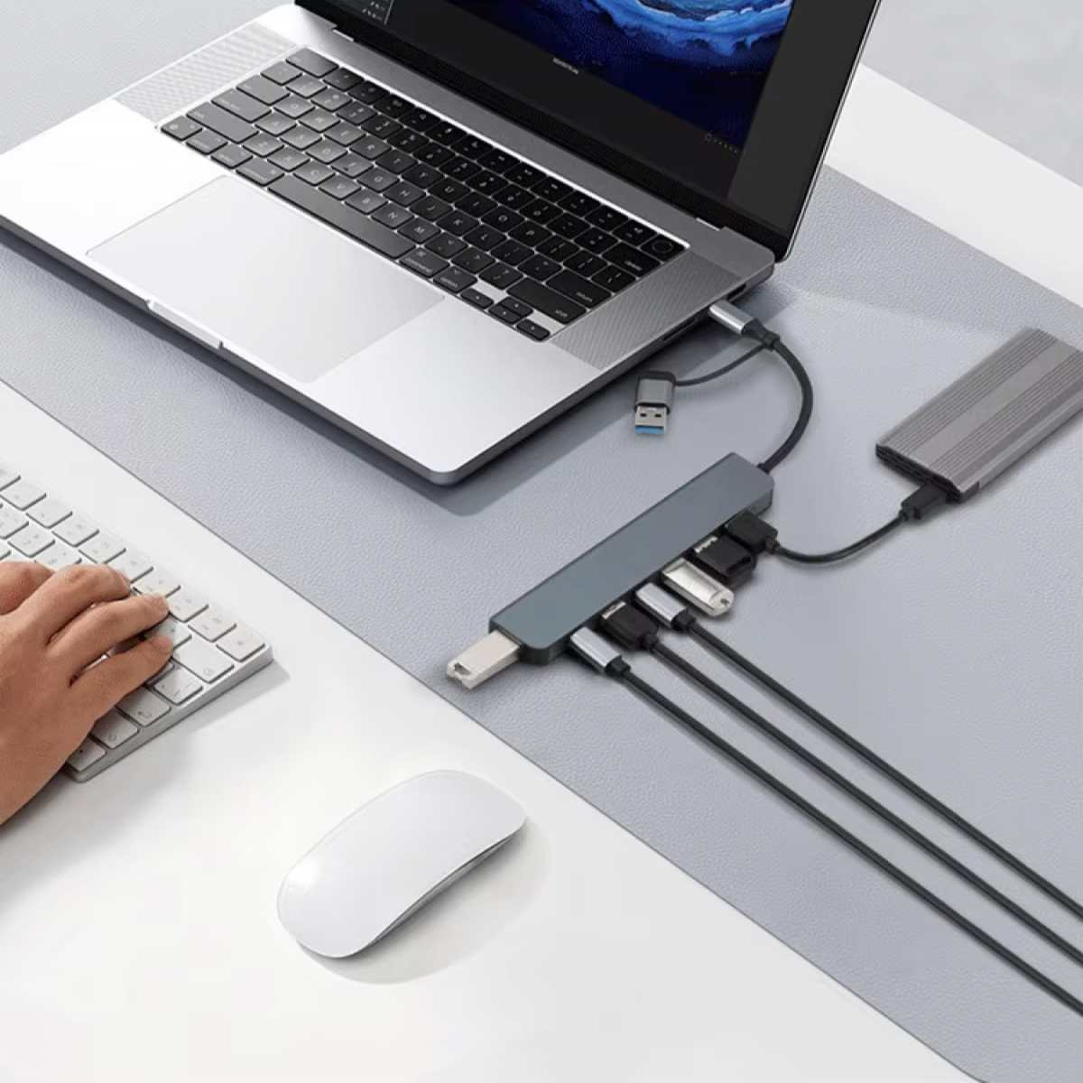 Ein Laptop, Tastatur, Maus und USB-Hub mit externer Festplatte sind angeschlossen.