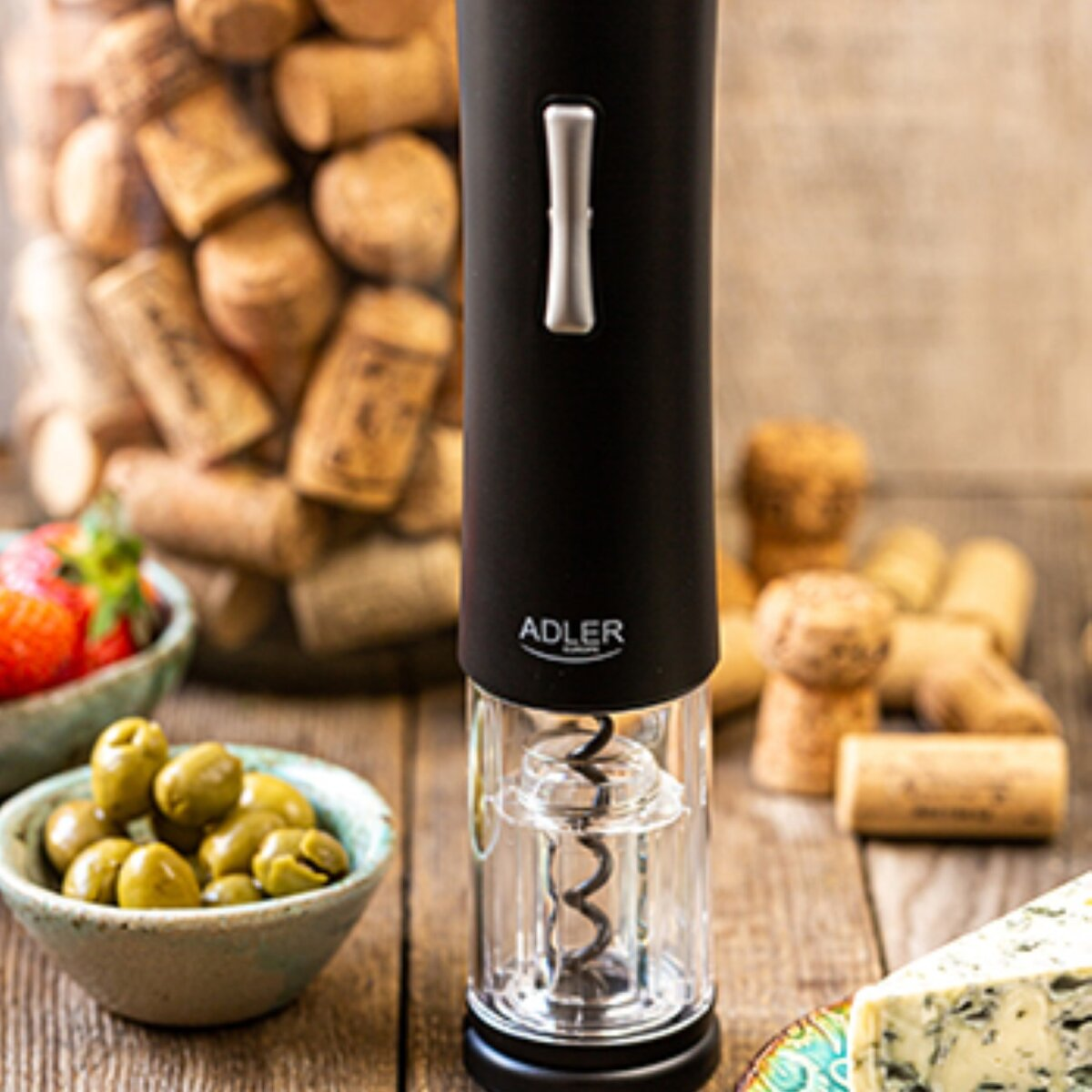 Sacacorchos eléctrico negro con aceitunas, fresas, queso y corchos.